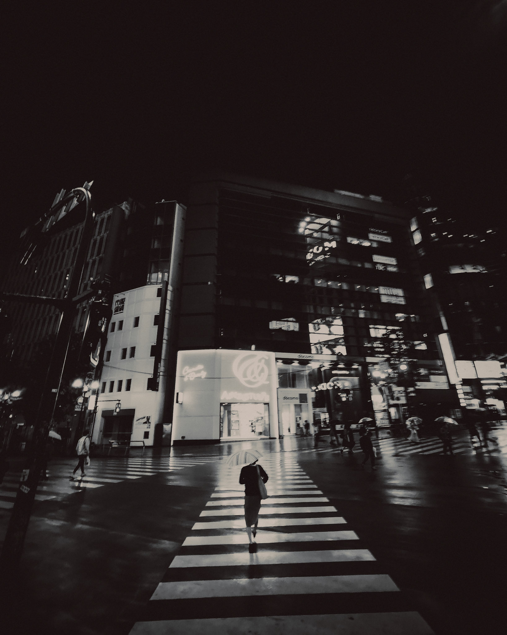 A woman with an umbrella in a pedestrian crossing, in black and white, Shibuya, Tokyo, Japan, October 2019, Huawei P30 Pro.