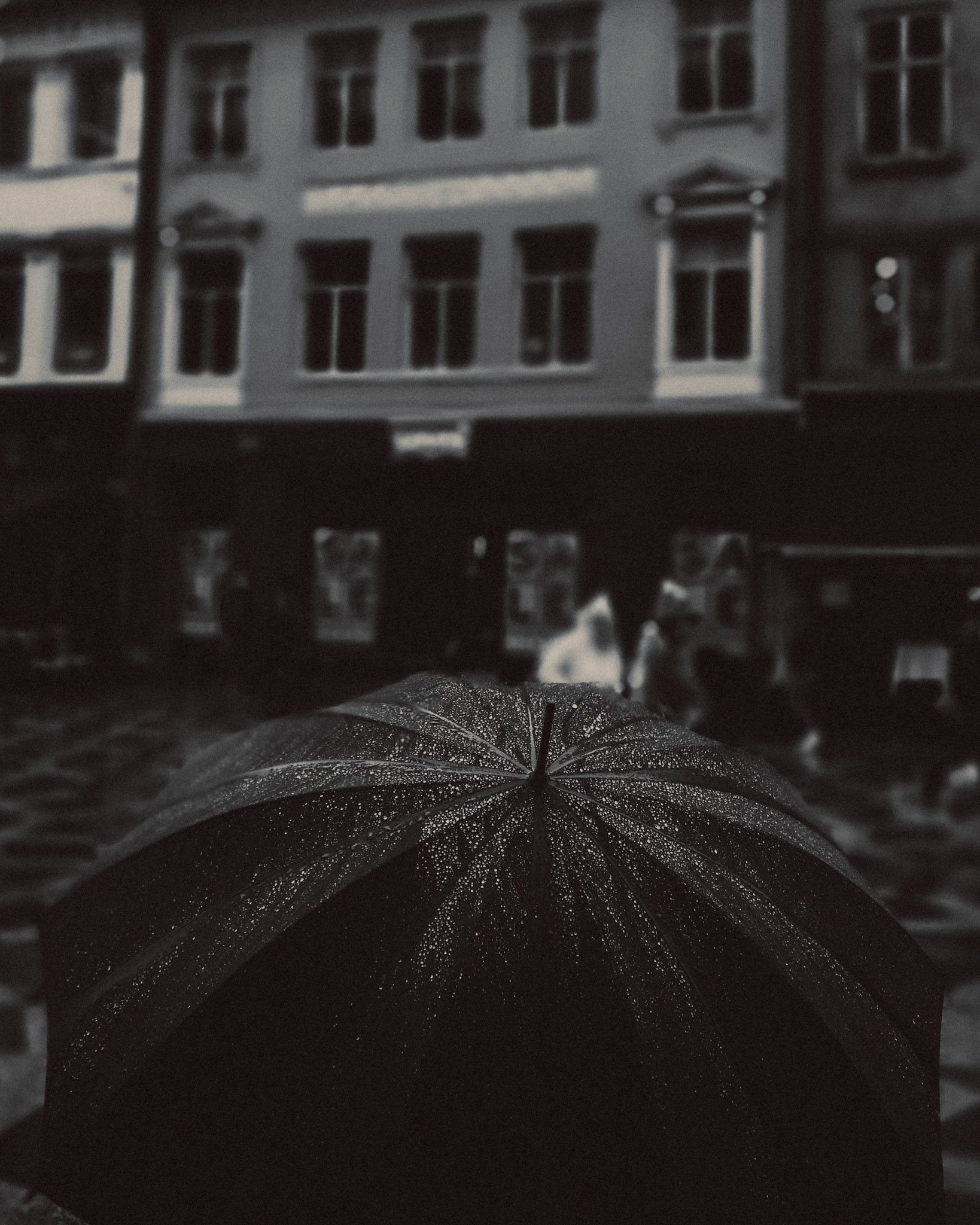 Raindrops on a black umbrella, in black and white, Strøget, Copenhagen, Denmark, July 2017, Huawei P10 Plus.