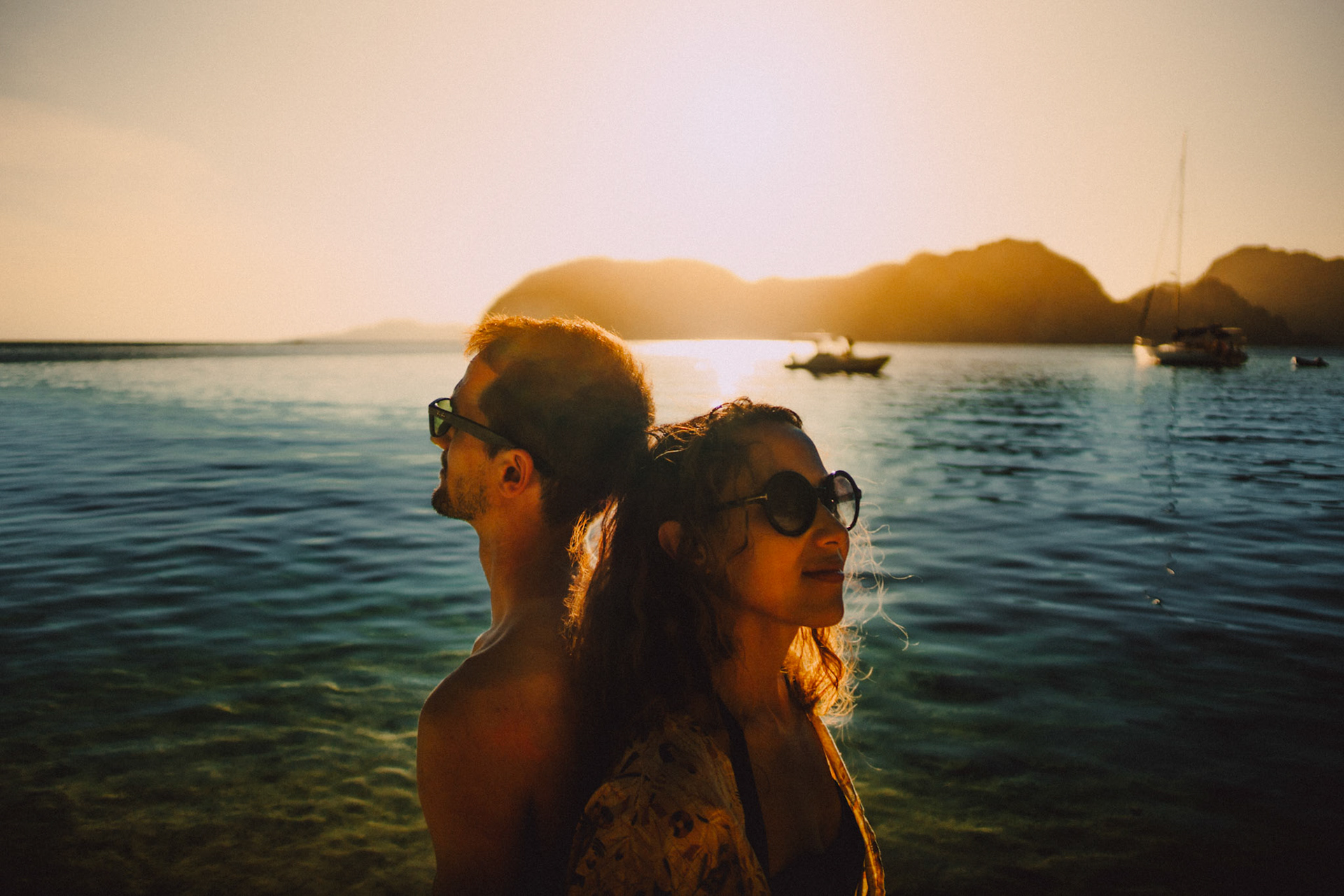 Moody adventure couple portraits in Entalula Island's secluded west-facing beach just moments before sunset, El Nido, Palawan, Philippines, Southeast Asia, April 2019, Sony A7III.