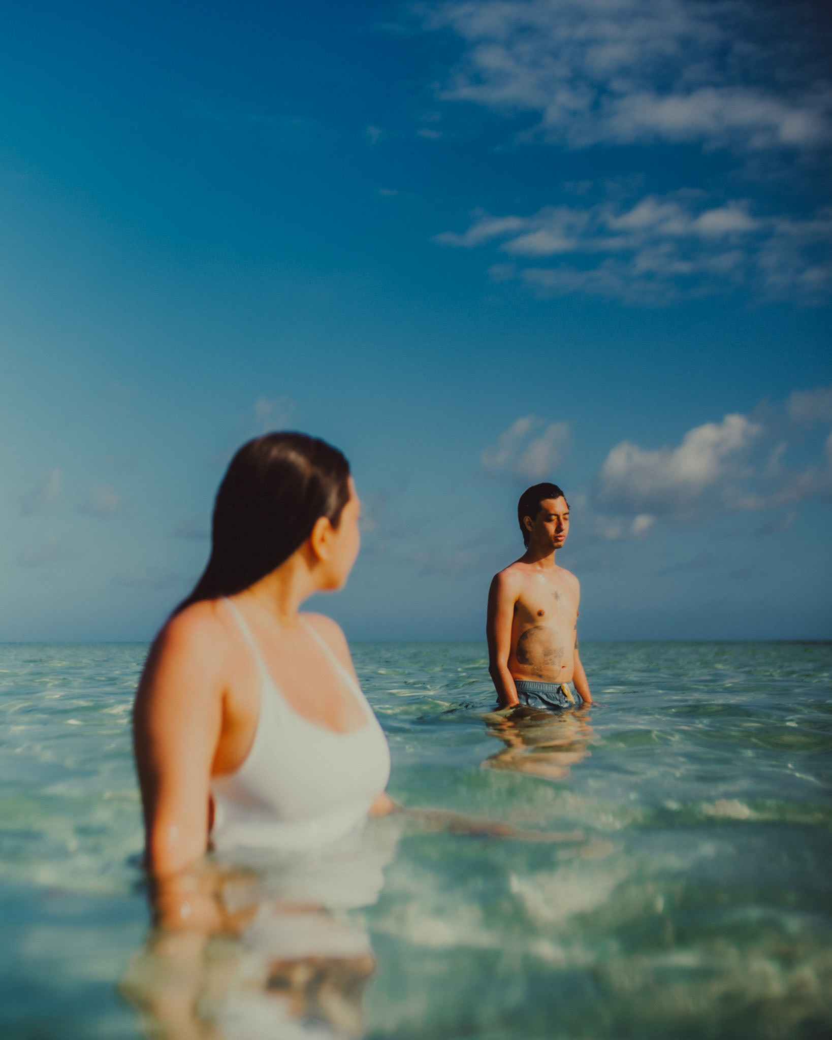 Waist-deep in clear and turquoise water on a submerged sandbar in Malinao Paradise, from Jeo and Bianca's island hopping honeymoon couple portrait shoot in Siargao Island, Philippines, Southeast Asia, February 2020, Sony A7III