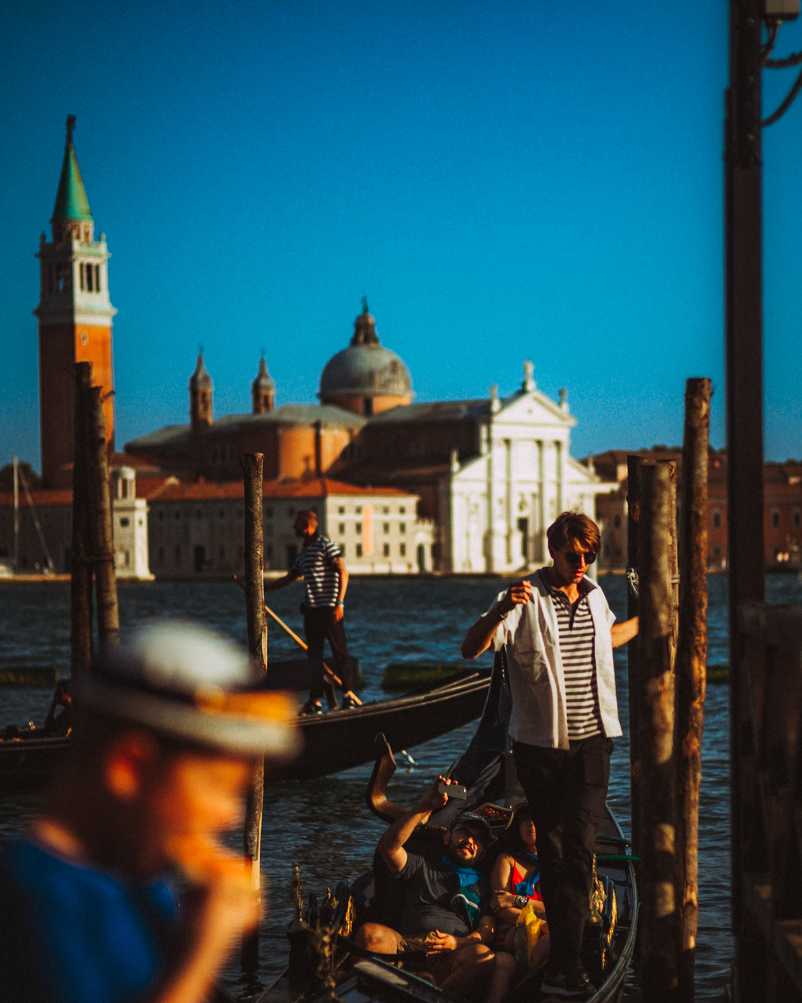 A gondolier at the Gondola Service Station near Piazza San Marco with the Church of San Giorgio Maggiore in the background, Venice, Italy, August 2017, Leica M.