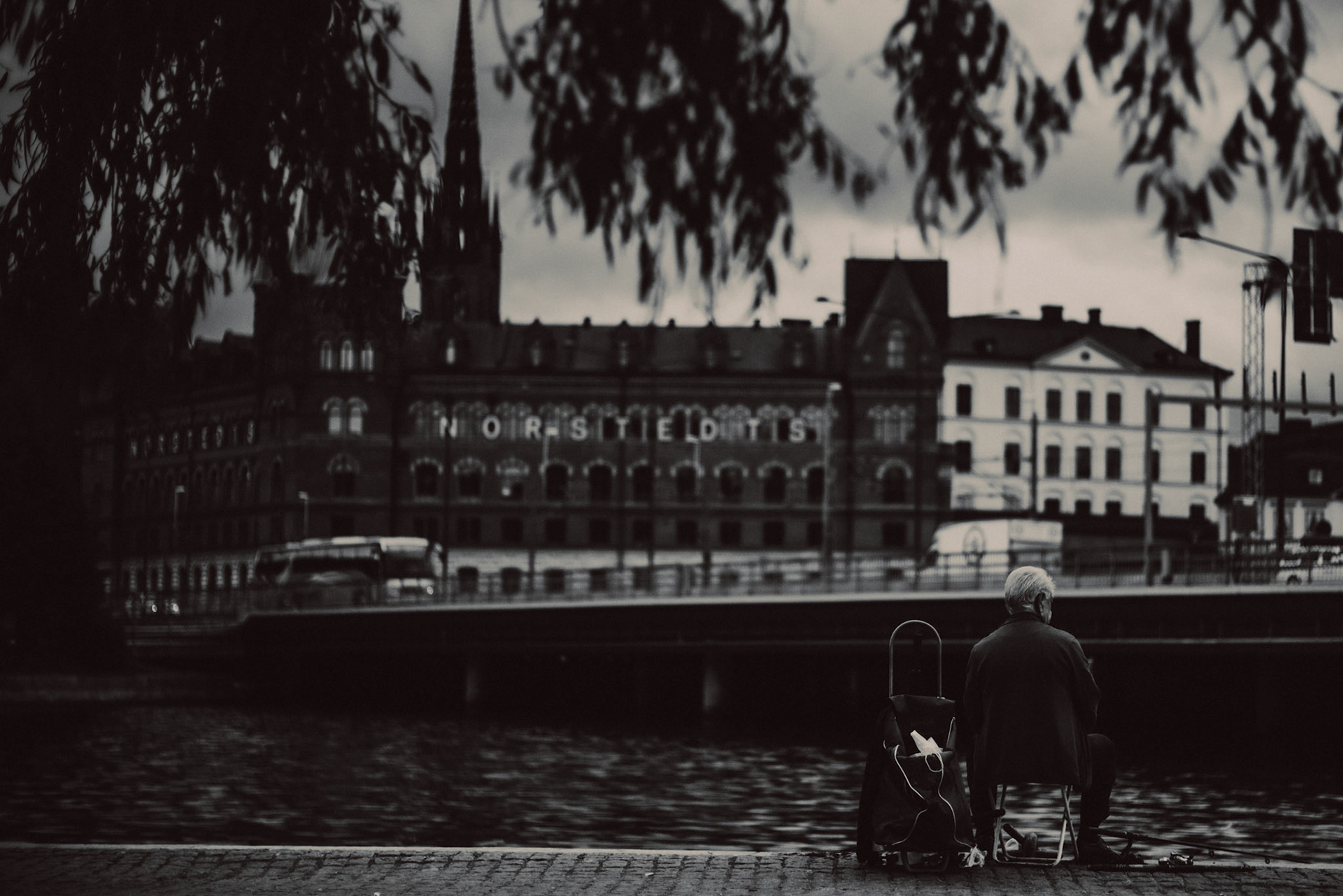 An old man with the Norstedt Building in the background, in black and white, Stockholm, Sweden, July 2016, Leica M.