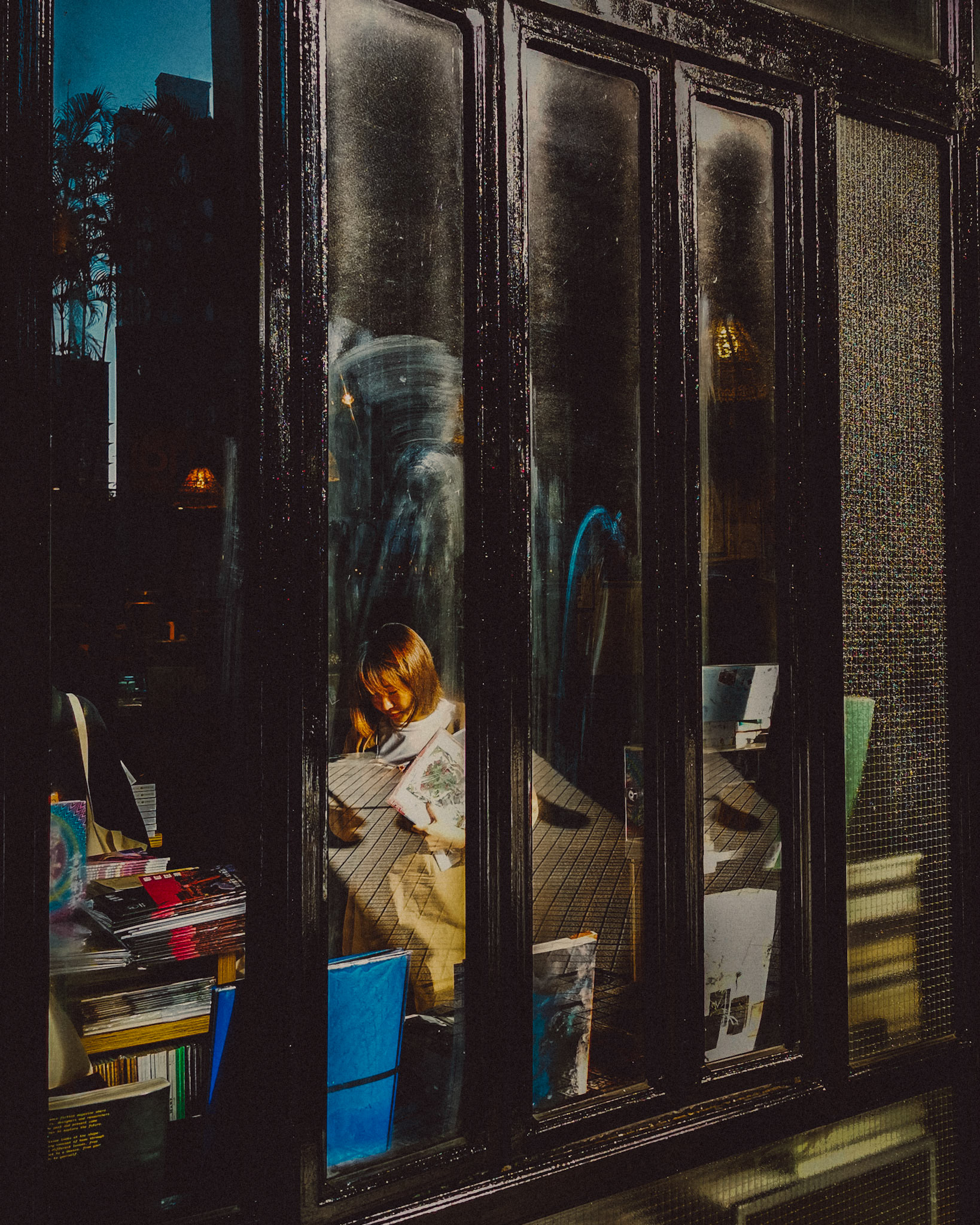 A woman browsing through books in Kubrick, Yau Ma Tei, Hong Kong, January 2020, Huawei P30 Pro.