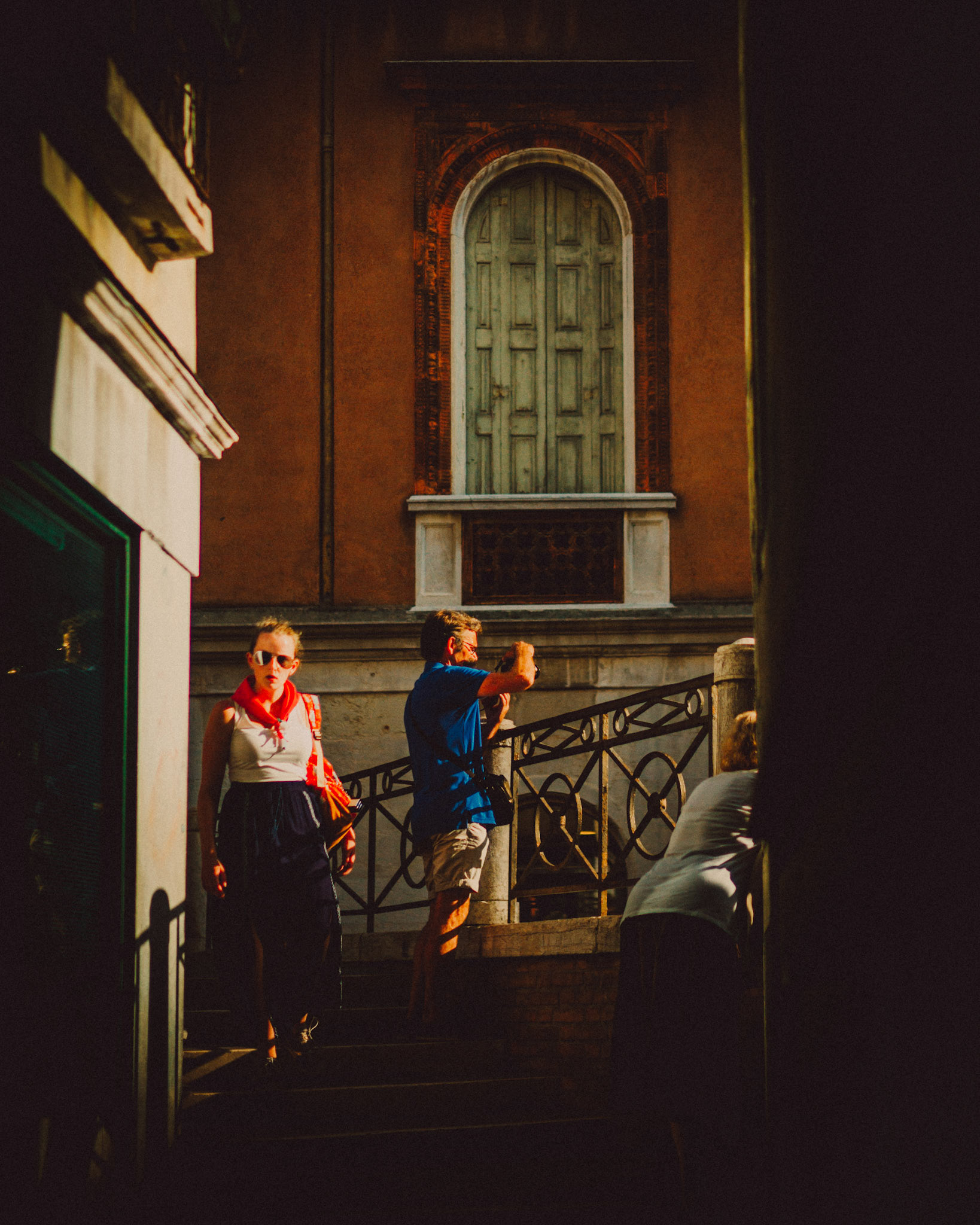A woman in sunglasses emerging from an alleyway, Venice, Italy, August 2017, Leica M.