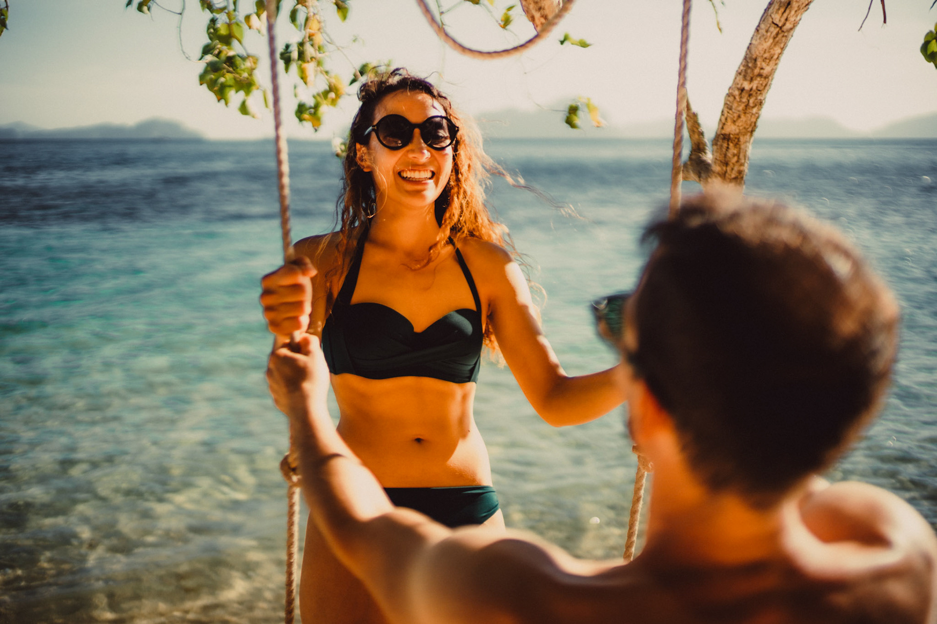 Candid and chill couple portraits on a swing in Paradise Beach, Cadlao Island, El Nido, Palawan, Philippines, Southeast Asia, April 2019, Sony A7III.