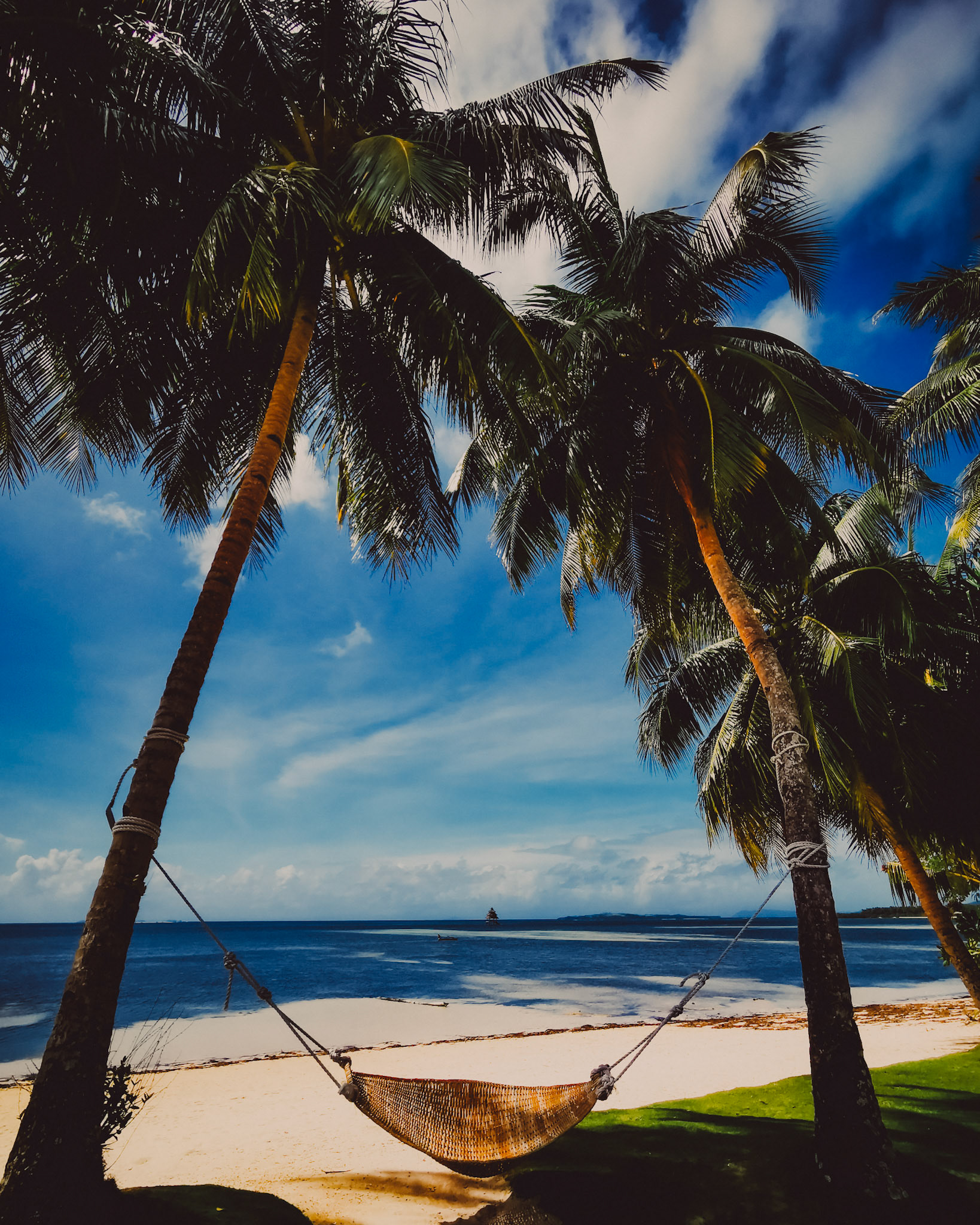 Bayud Boutique Resort's beach front with a hammock hanging in between two palm trees, Siargao Island, Philippines, February 2020, Huawei P30 Pro.
