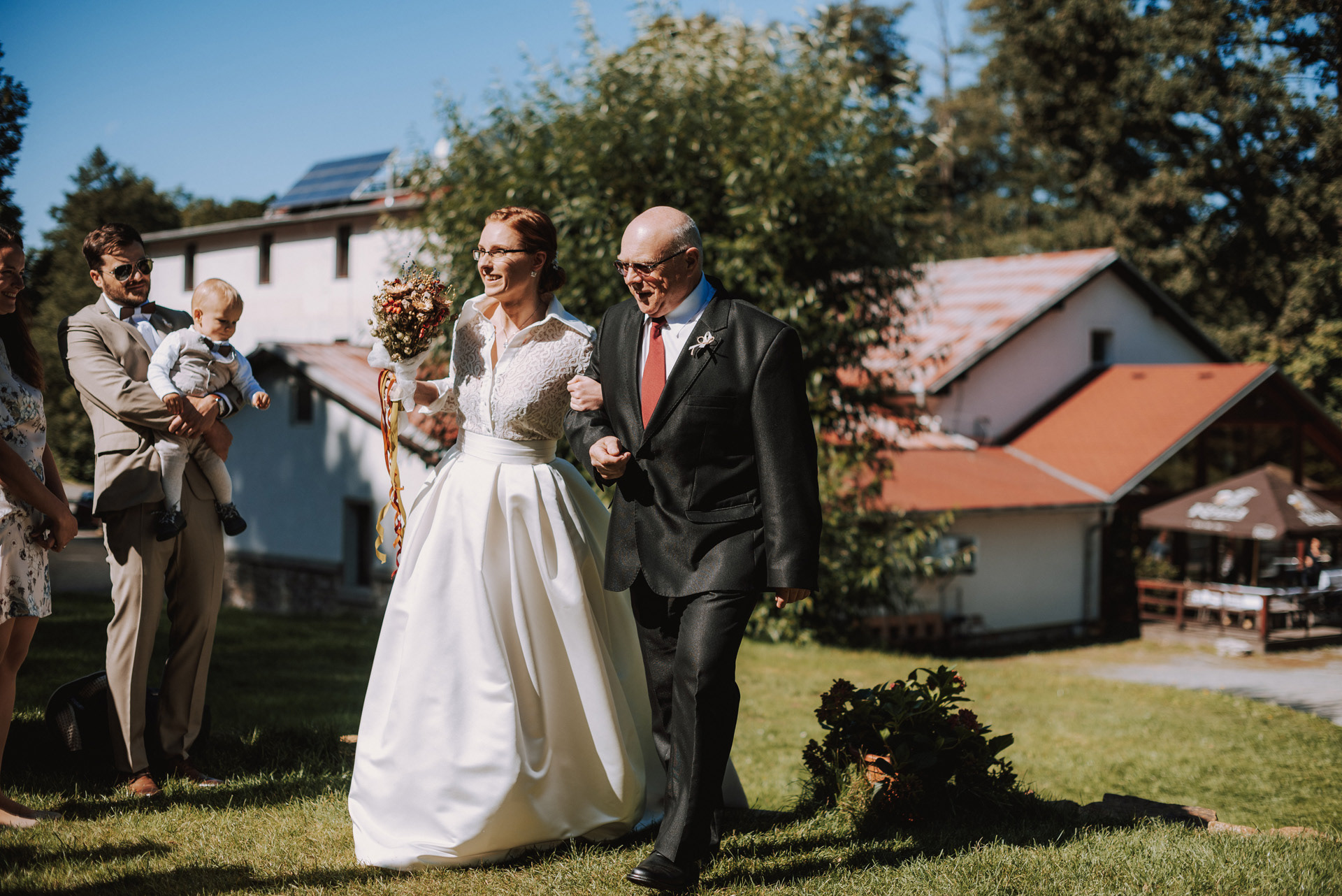 tatínek vede nevěstu k obřadu v altánku