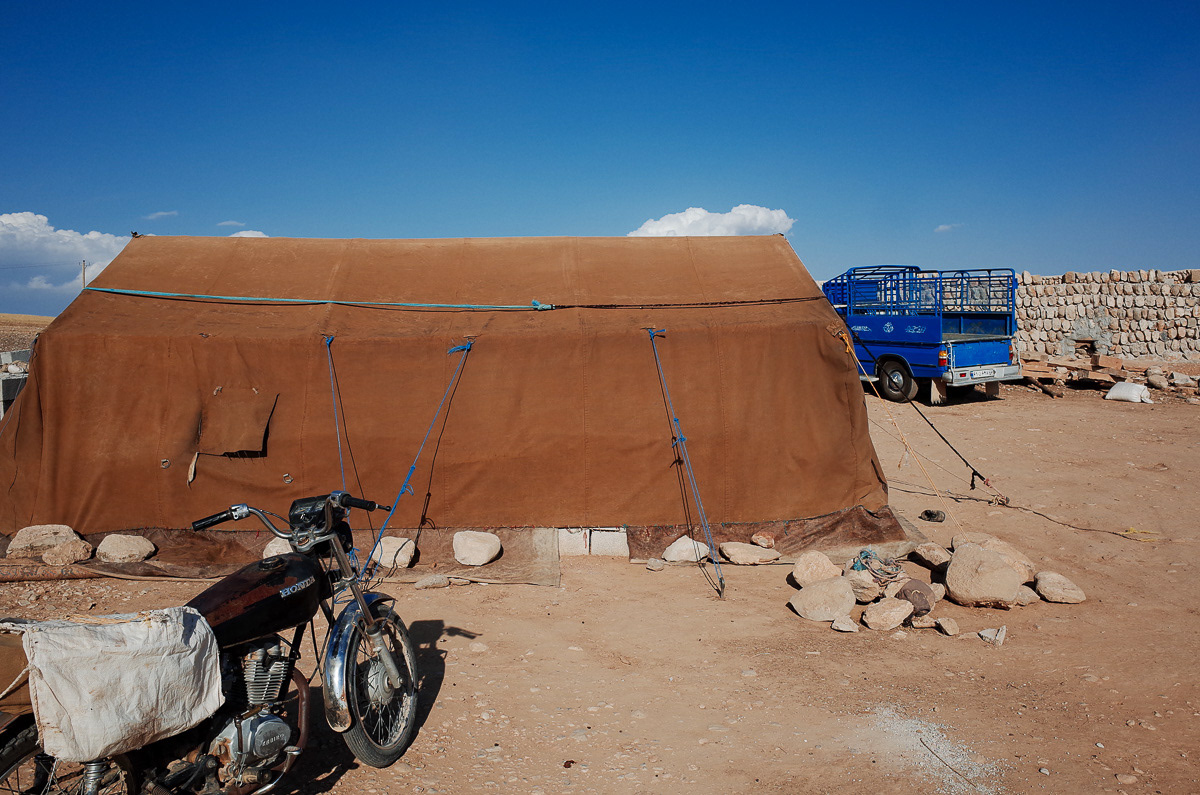 Une moto ainsi qu'un antique pick-up attendent à la sortie de la tente. La motorisation des nomades est une avancée majeure dans la survie de leur mode de vie. Elle facilite la transhumance et permet de se rendre rapidement en ville en cas de besoin.
