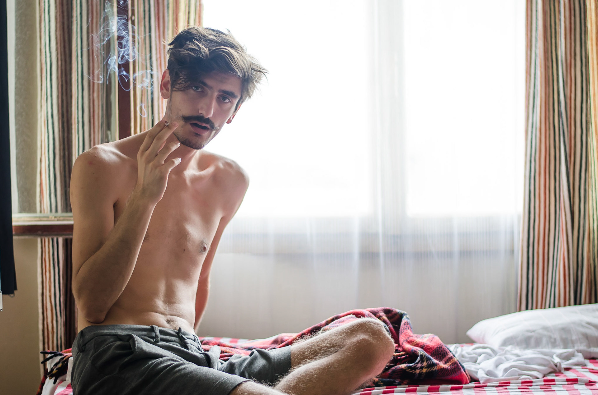 Shirtless man smoking on bed. Portrait, moustache, retrato, masculino, homem, fumando, sessão fotográfica, boudoir