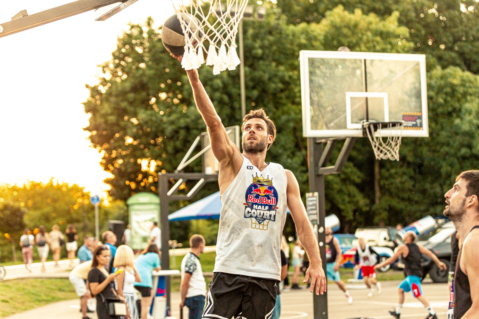 Krepšininkas atlieka metimą Red Bull Half Court turnyro trys prieš tris metu