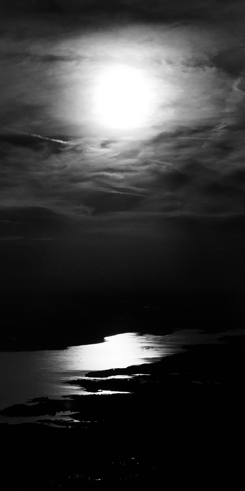 The sun at dusk upon water.
