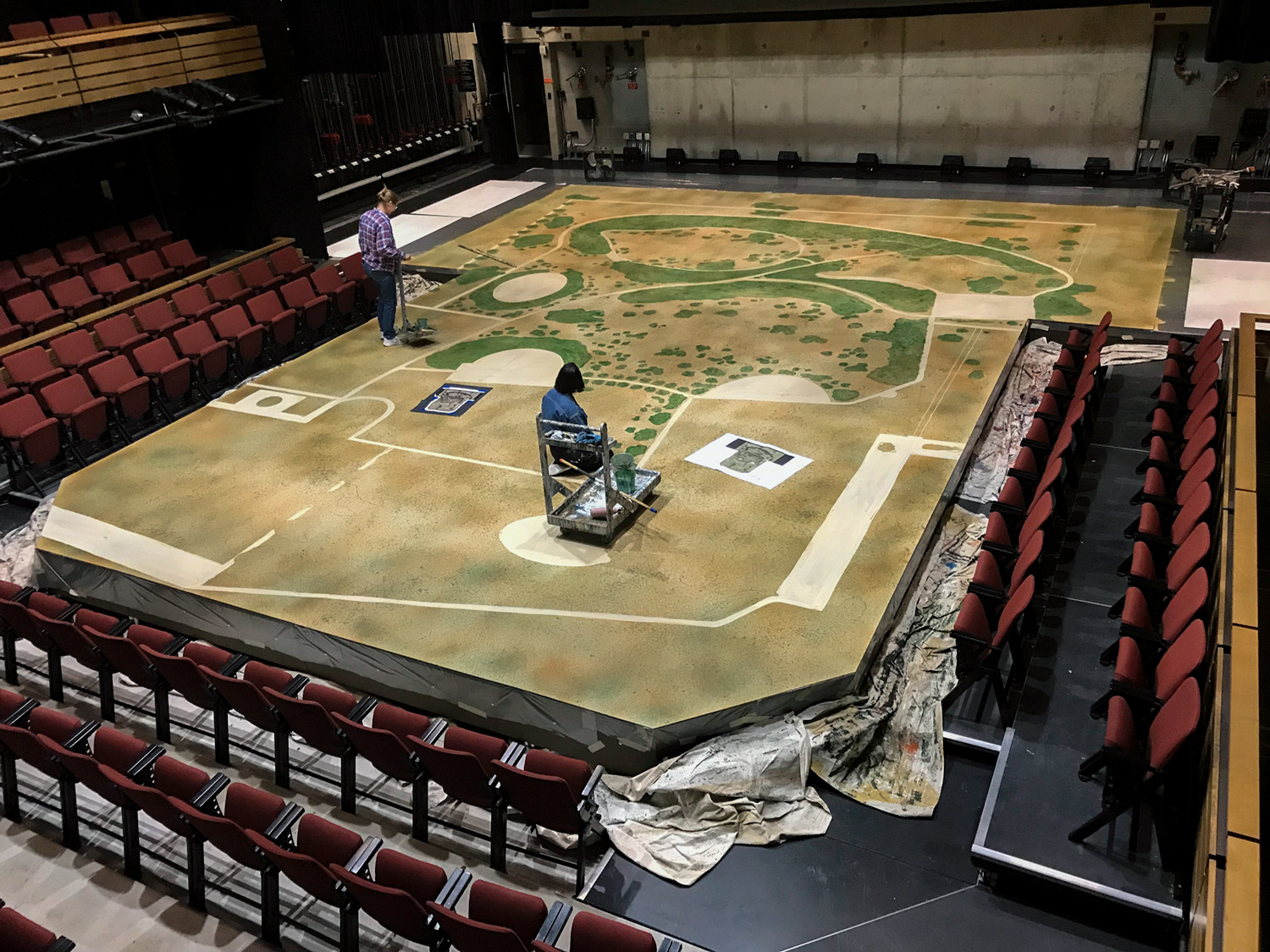 In process deck painting for Sense and Sensibility at University of Michigan. Seen in jean jacket.