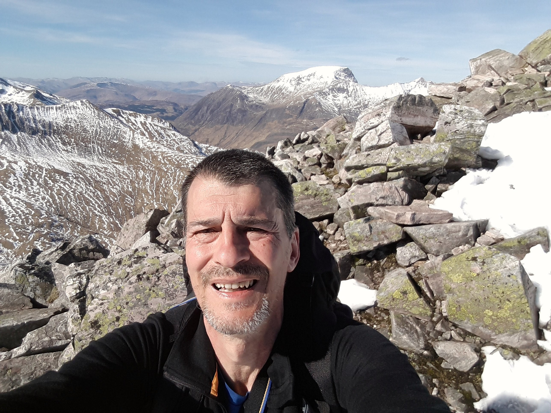 Photo of author on top of Bennein Mor in the Scottish highlands. Yes that's Ben Nevis in the background.