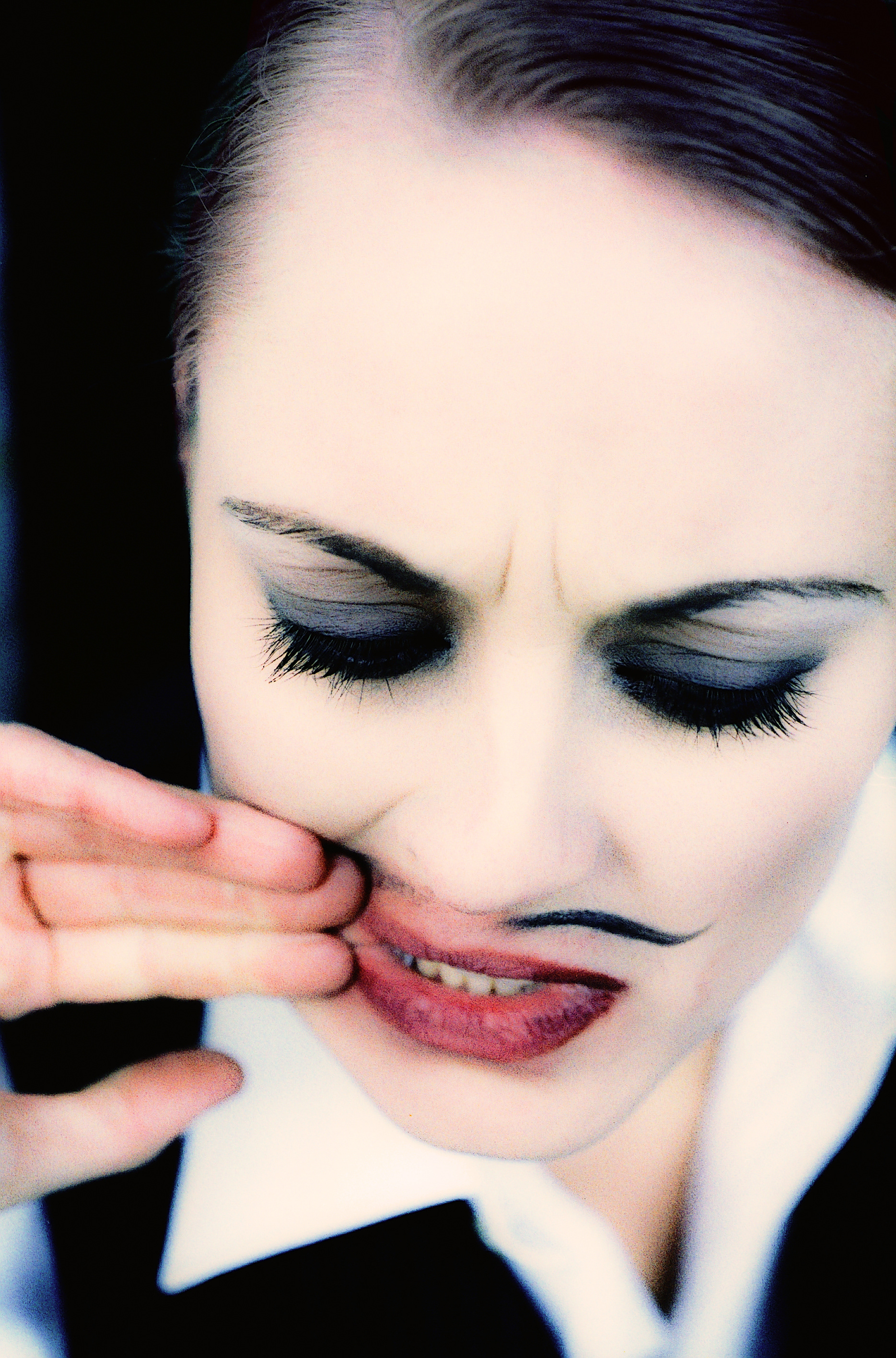 Jonnas face with eyes closed and smearing her painted moustache