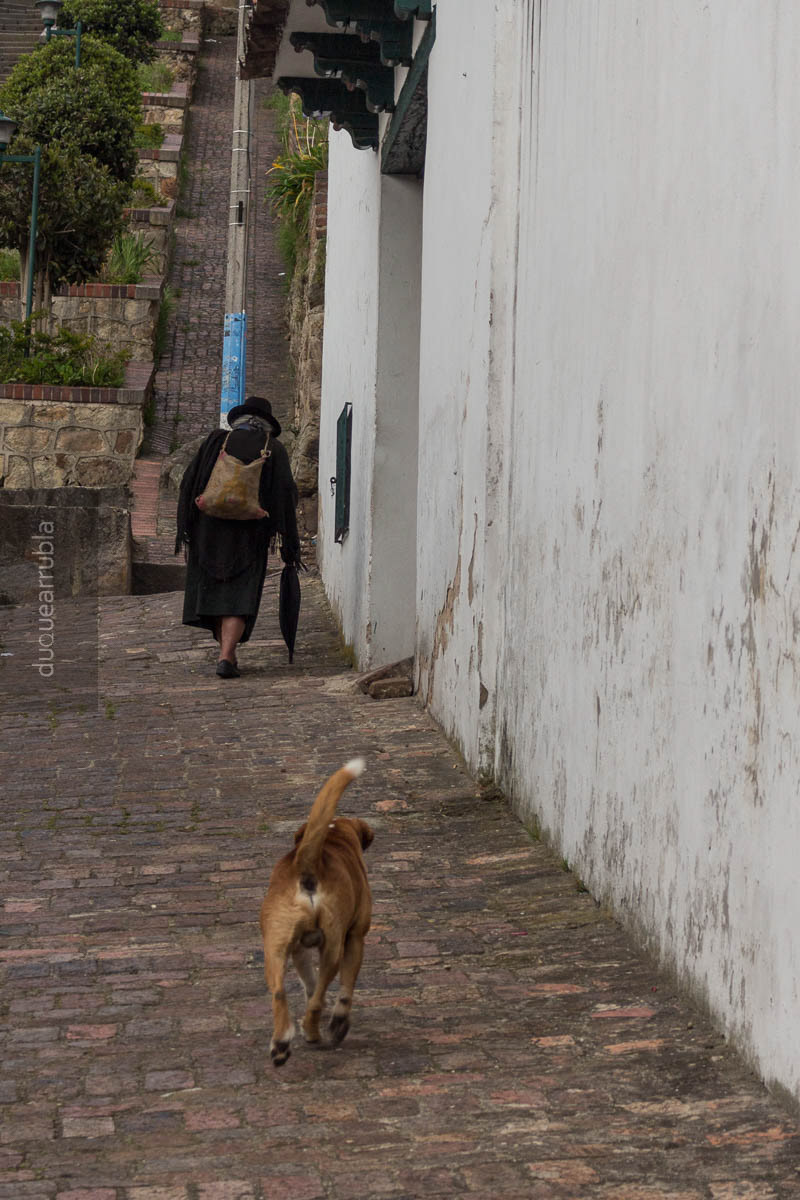 La doña y su perro. Monguí, Colombia. 2017. ♪Va camino de la iglesia, lleva en su mano un rosario…♪ * Su nieta nunca falta en sus oraciones. Ahora todos están lejos menos Canela aunque ella no pueda acompañarla a la capilla