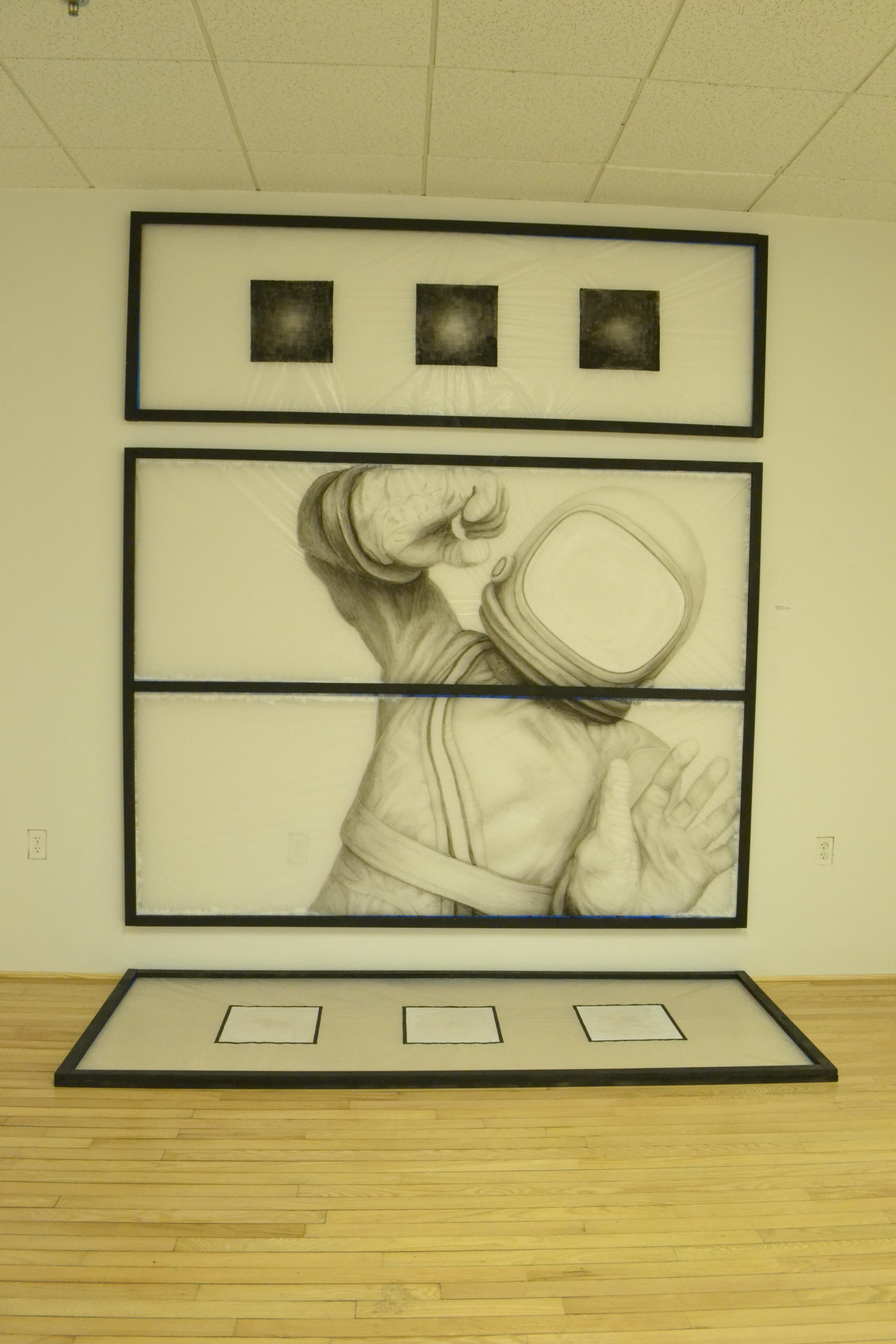 Close up picture showing the 3 wood frames containing the ink on glassine drawings. The center frame is 8' x 6' ft in dimensions with a large spaceman.