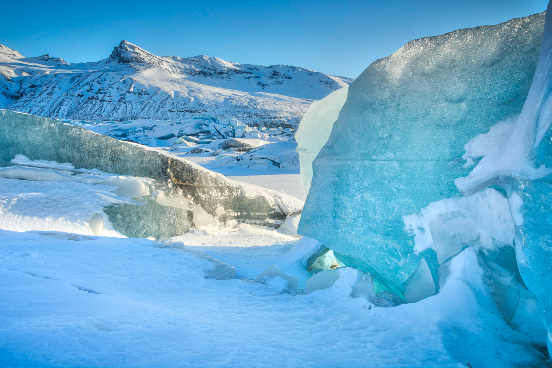 Icebergs broken off of of Svínafellsjökull, trapped in the frozen lagoon at the base of the glacial tongue.VatnajökulsþjóðgarðurAusturland, IcelandFebruary 9, 2016This is an HDR image consisting of 5 exposures merged in Photomatix Pro. Additional processing in Lightroom and Photoshop.PENTAX K-3, Sigma 18-250mm f/3.5-6.3 DC OS HSMISO 100 18 mm  ¹⁄₂₀ sec at ƒ / 14