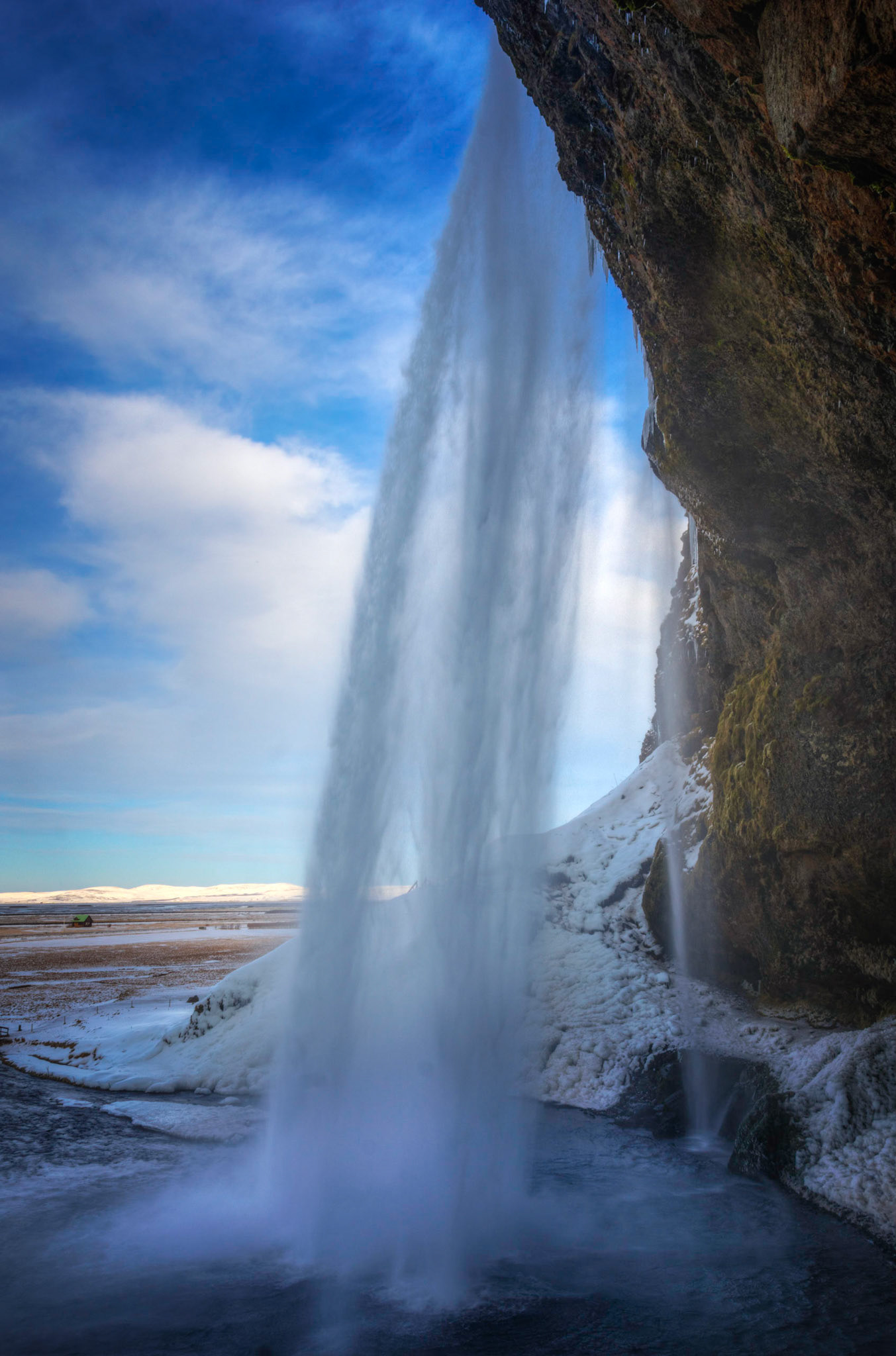Behind Seljalandsfoss, mid-afternoon in winter.Suðerland, IcelandFebruary 8, 2016This is an HDR image consisting of 5 exposures merged in Photomatix Pro. Additional processing in Lightroom and Photoshop.PENTAX K-3, Sigma 18-250mm f/3.5-6.3 DC OS HSMISO 100 18 mm  ¹⁄₁₂₅ sec at ƒ / 10