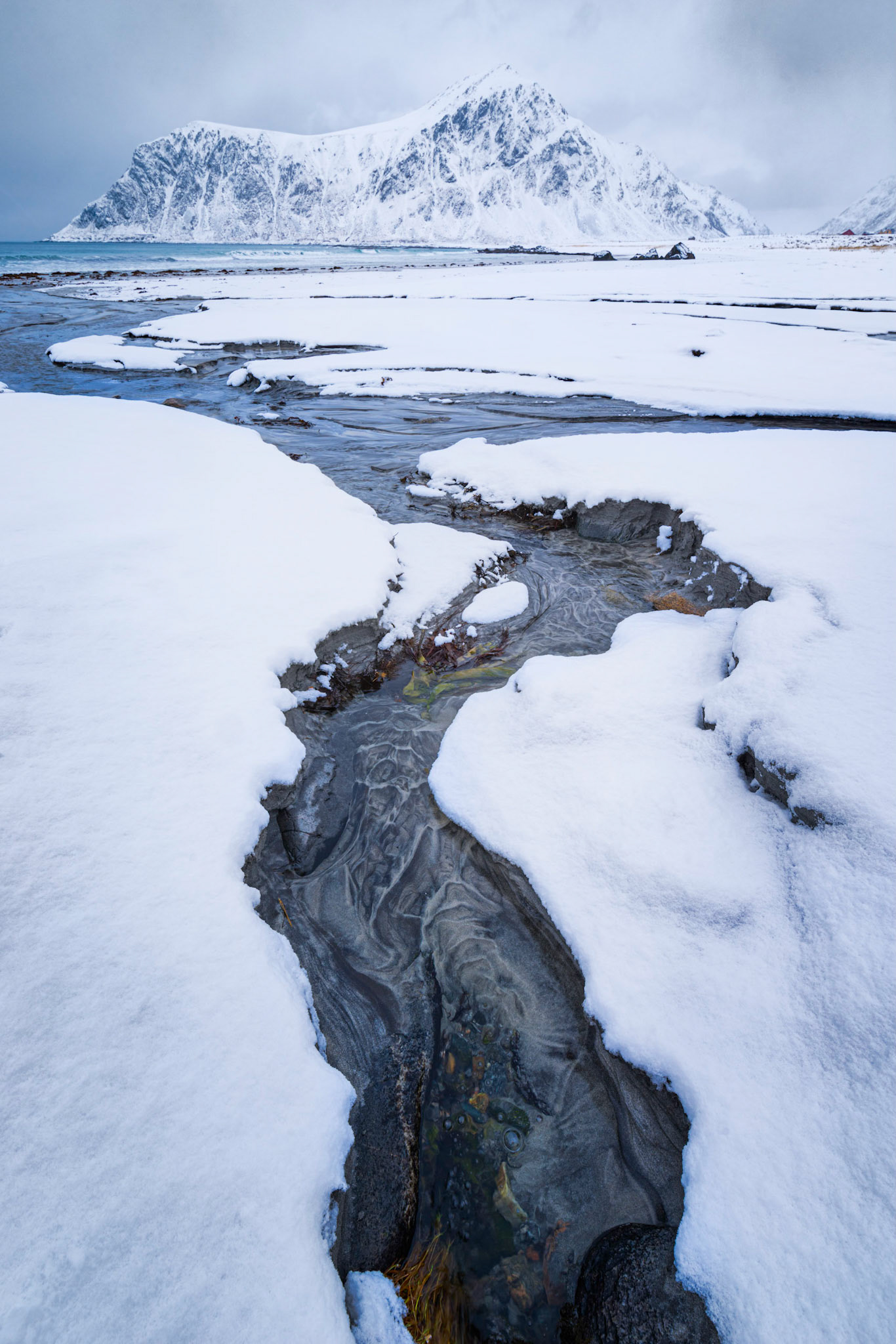 Skagsanden Beach, where minerals in the streams create ever-changing patterns of black and grey.   It's also one of the more popular beaches in Lofoten for surfing year-round.Flakstad, Nordland, NorwayMarch 20, 2018Pentax K-1, HD PENTAX-D FA 15-30mm F2.8ED SDM WRISO 100 18 mm  ¹⁄₄₀ sec at ƒ / 18