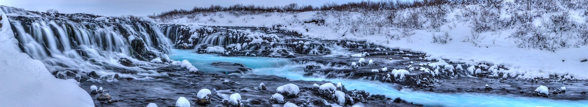 Panoramic image from the base of Bruarfoss, just below the bridge.Suðerland, IcelandJanuary 29, 2016This is an HDR panoramic image consisting of 15 frames comprised of 3 exposures each. HDR processing performed in Photomatix Pro.  Panoramic stitching performed in Photoshop. Additional processing performed in Lightroom and Photoshop.PENTAX K-3, Sigma 18-250mm f/3.5-6.3 DC OS HSMISO 100 53 mm  ¼ sec at ƒ / 11