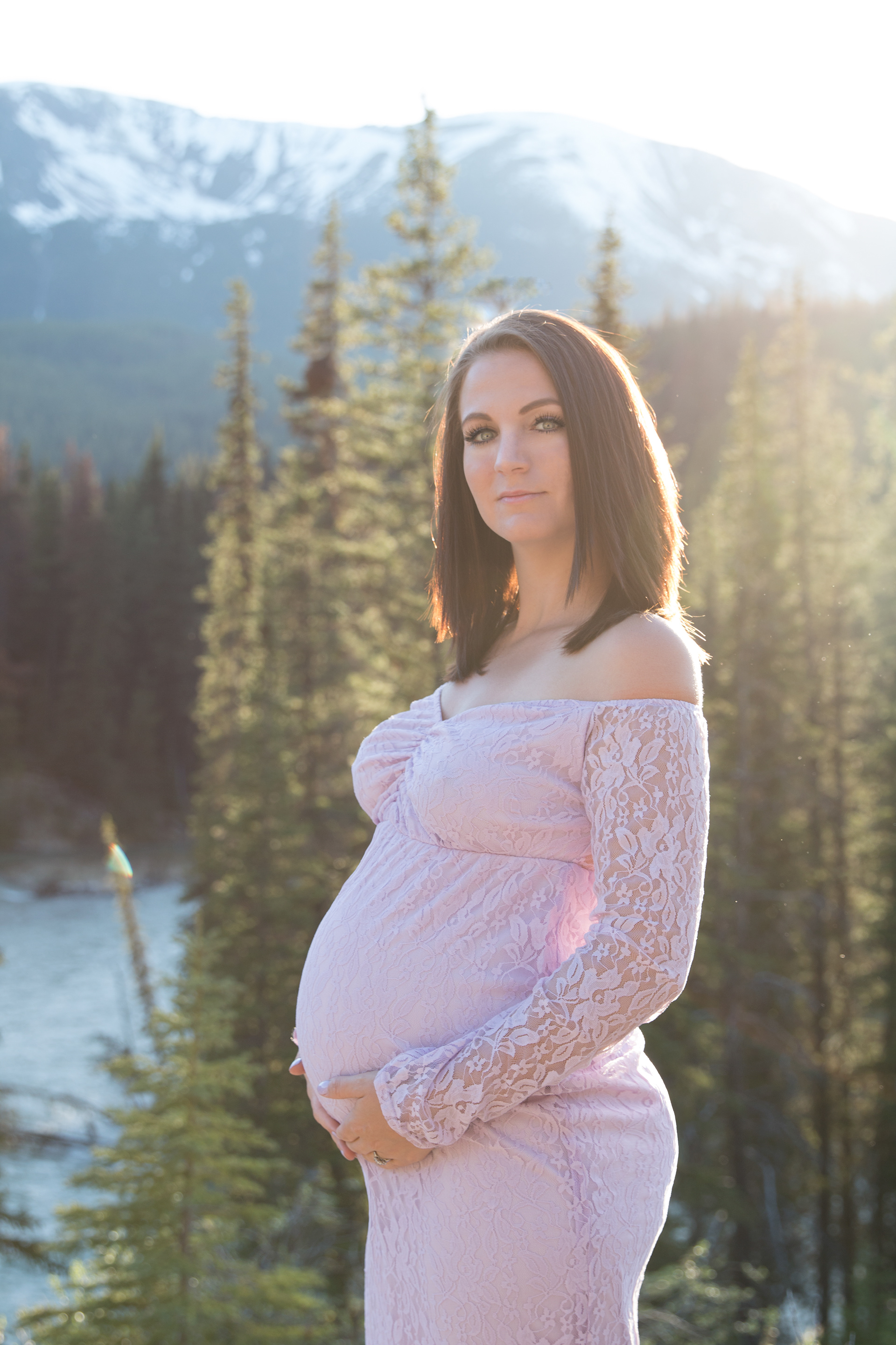 Mom holding belly in mountains
