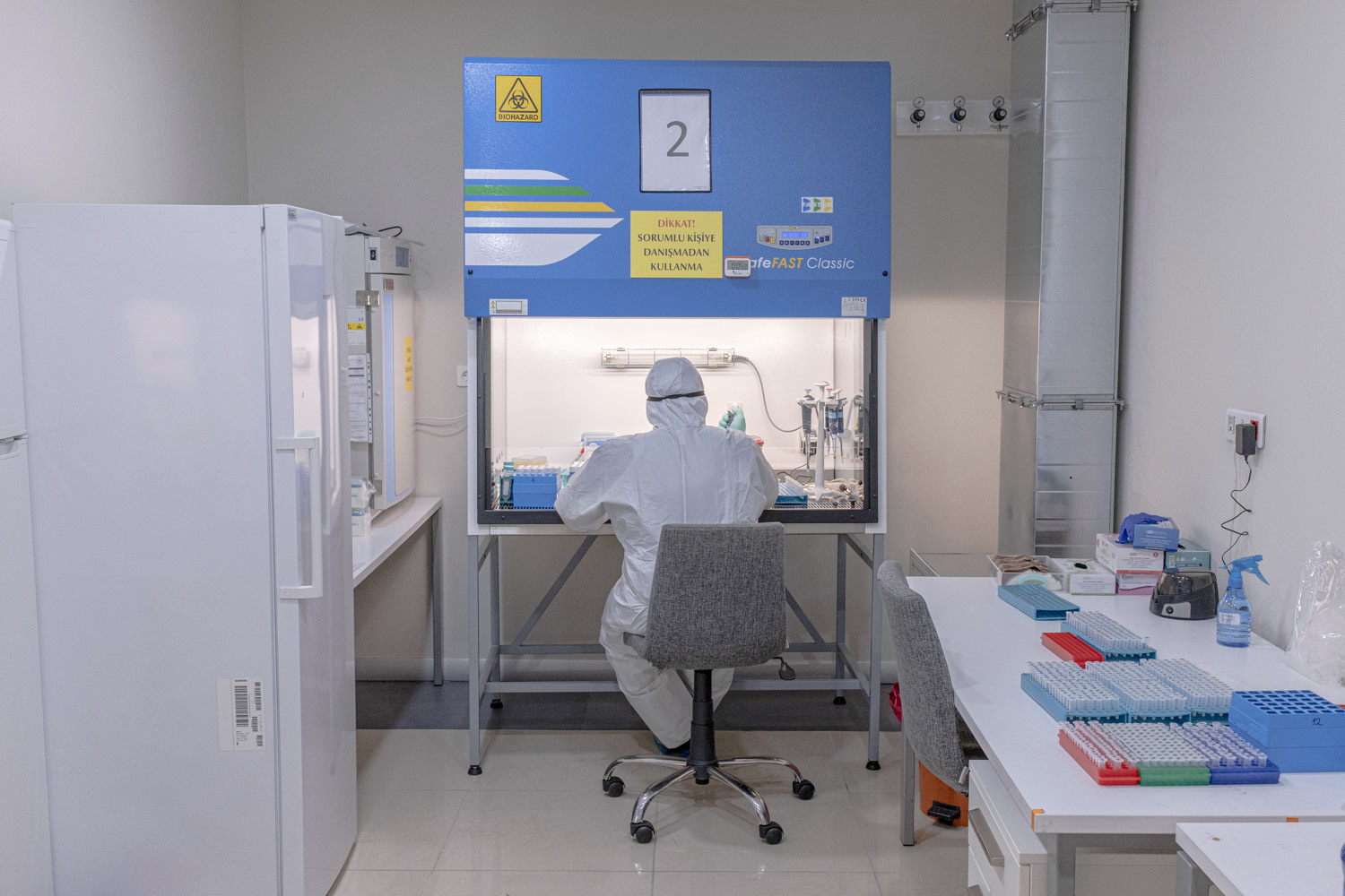A molecular biologist wearing protective equipment as she process to extract viral RNA in a high safety laboratory chamber at a private hospital in Istanbul on 1 May 2020.