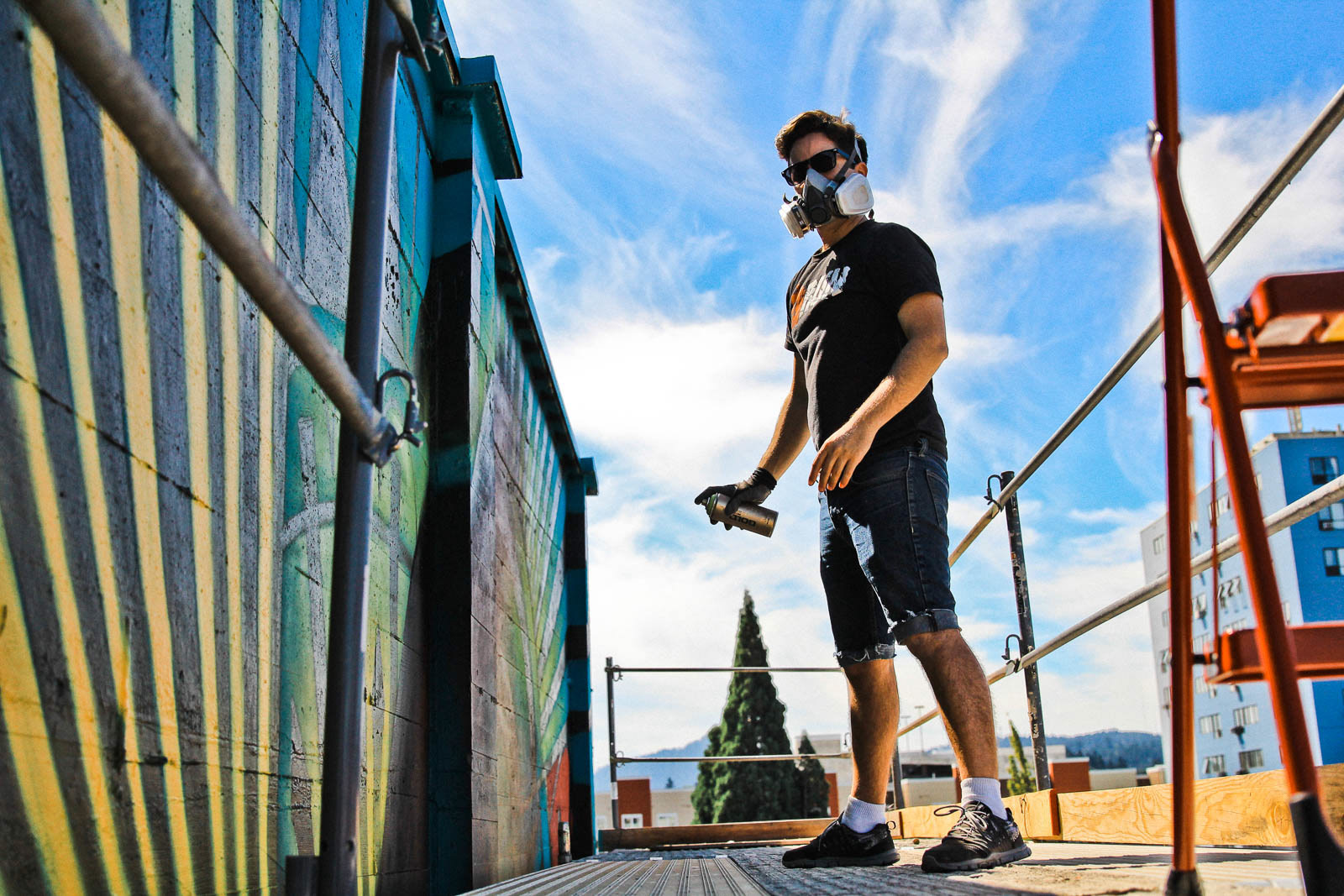 20x21 Eugene Mural Project artist spraypainting on wall