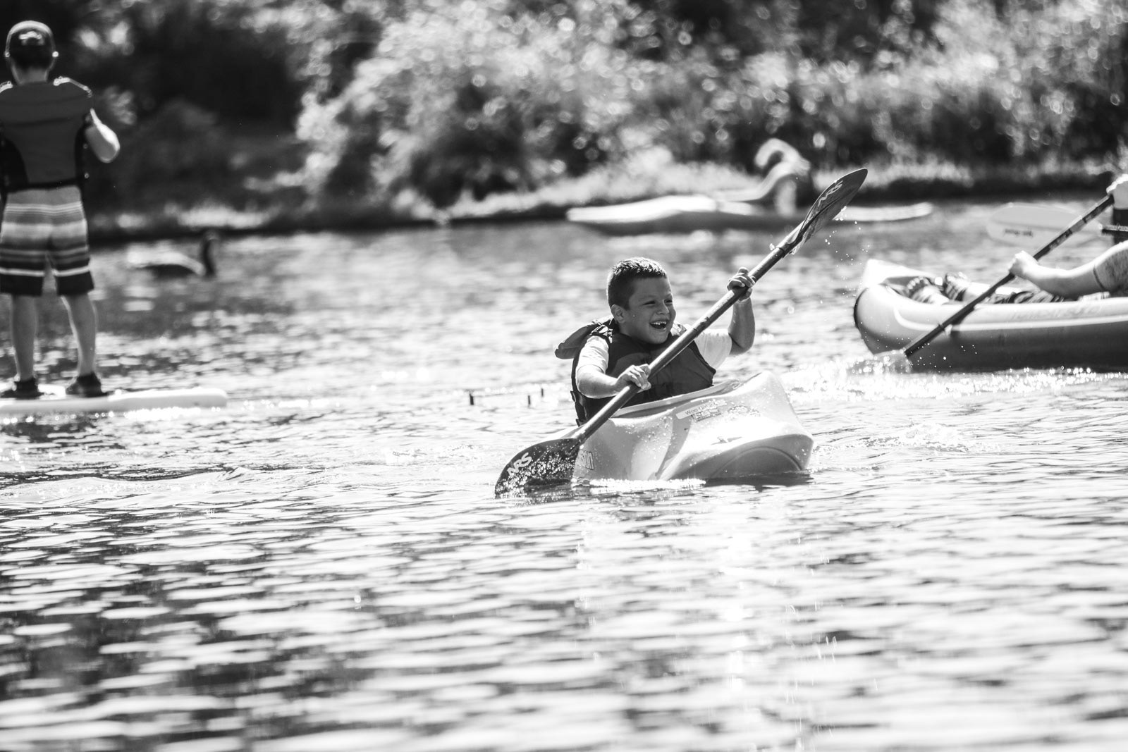 Boy in kayak paddles down river in an event for McKenzie River Trust