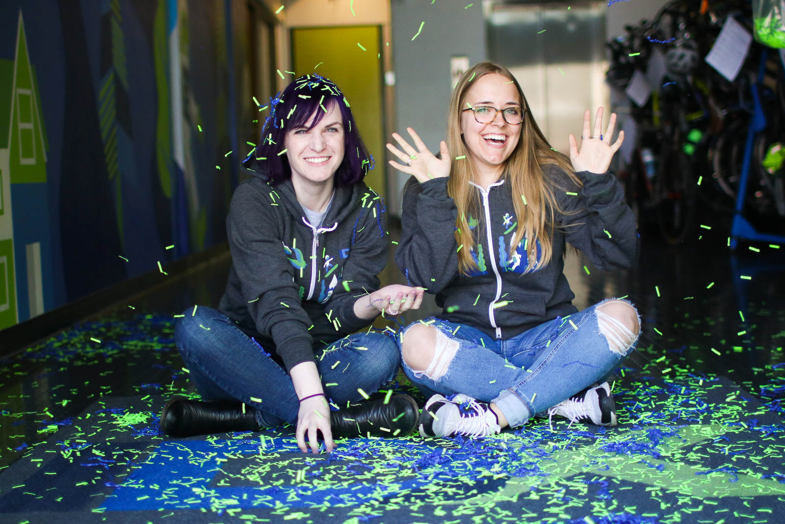 Two women celebrating with confetti at IDX Broker headquarters