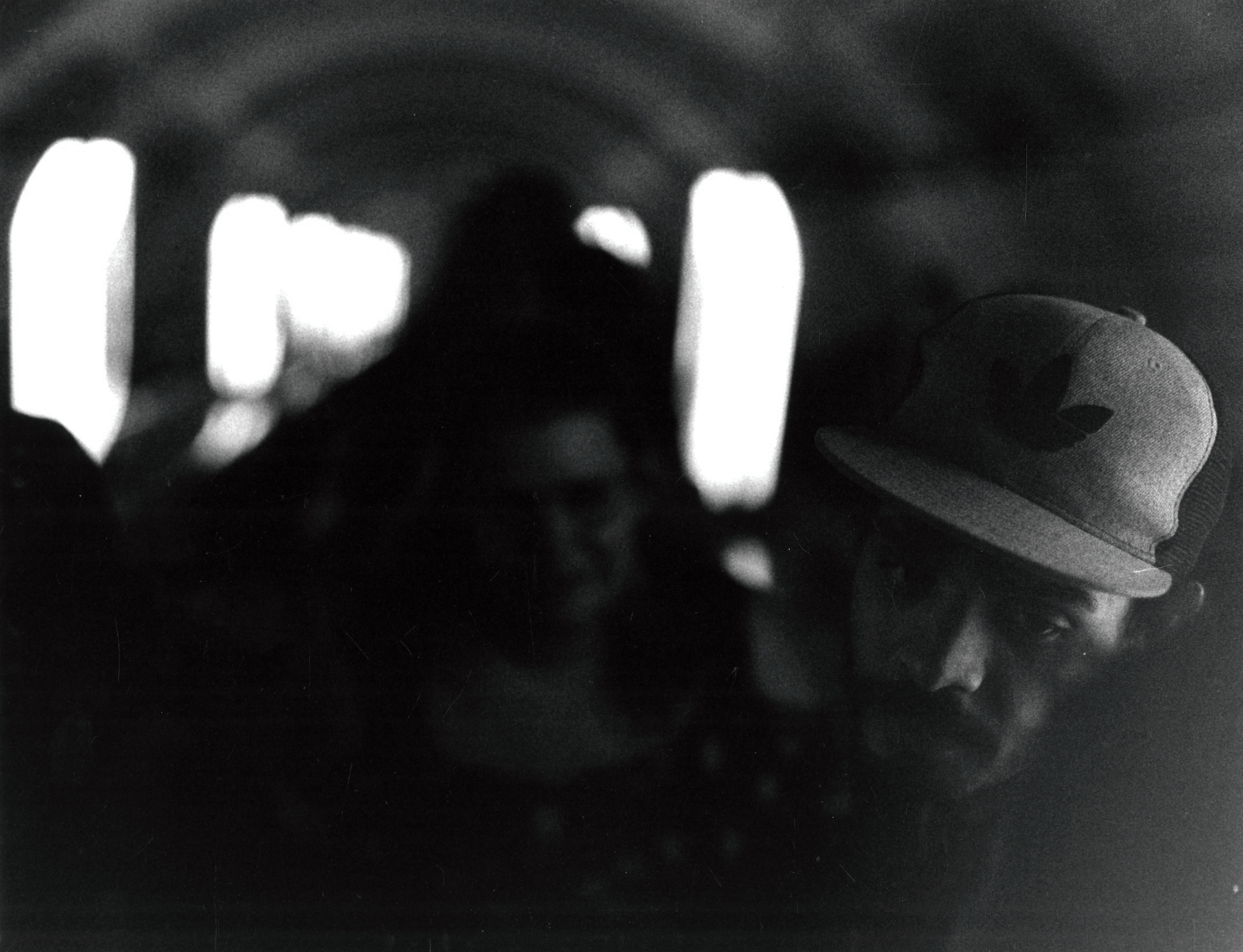 half of Malik's face is lit by the dim lights on the Kiev underground escalator