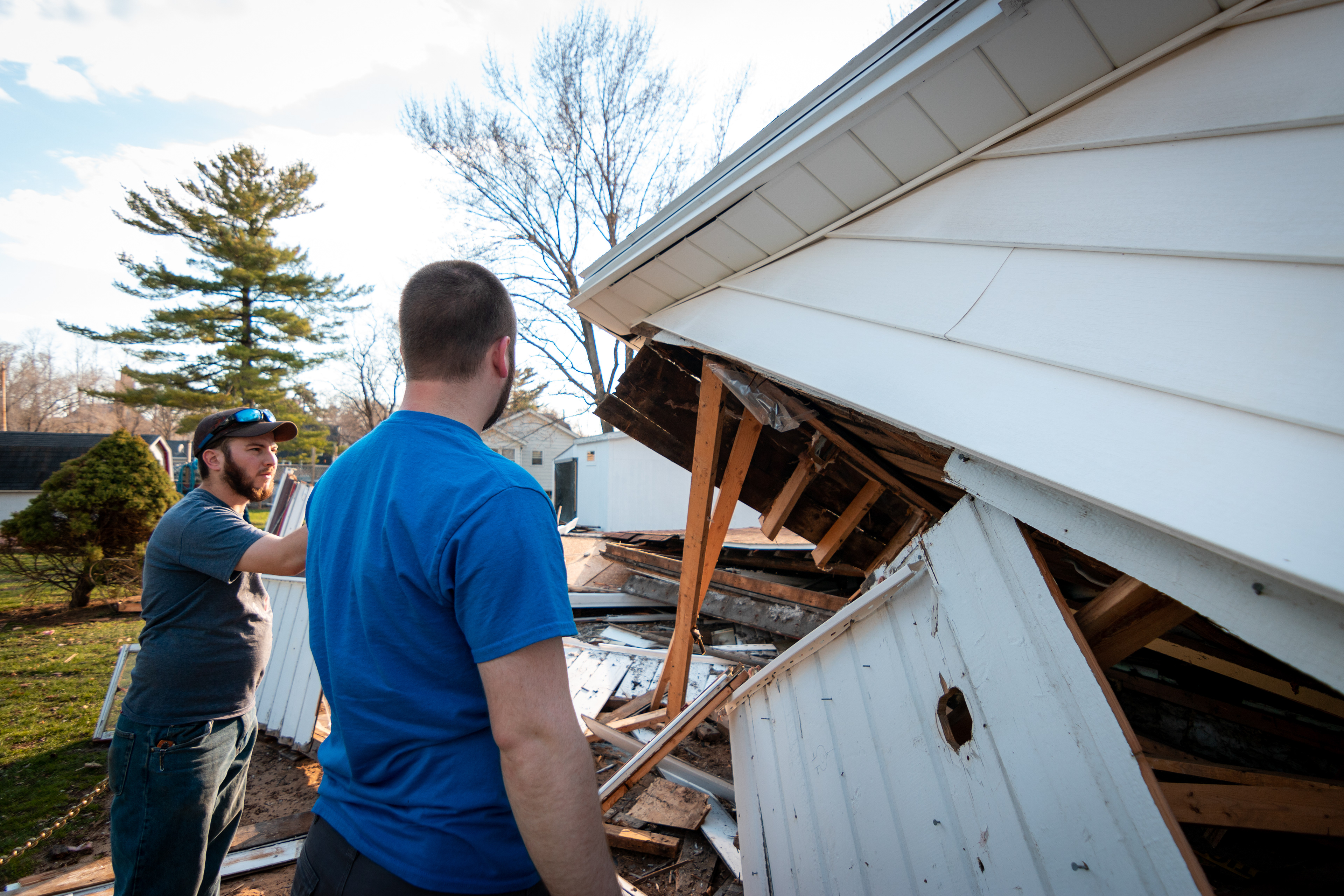 Matt and Joe Travis inspect their parents home after it is destroyed.