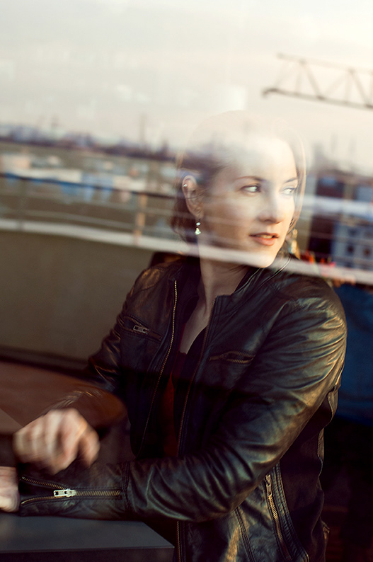 portrait edina müller, parakanutin. blick durch die scheibe eines cafes