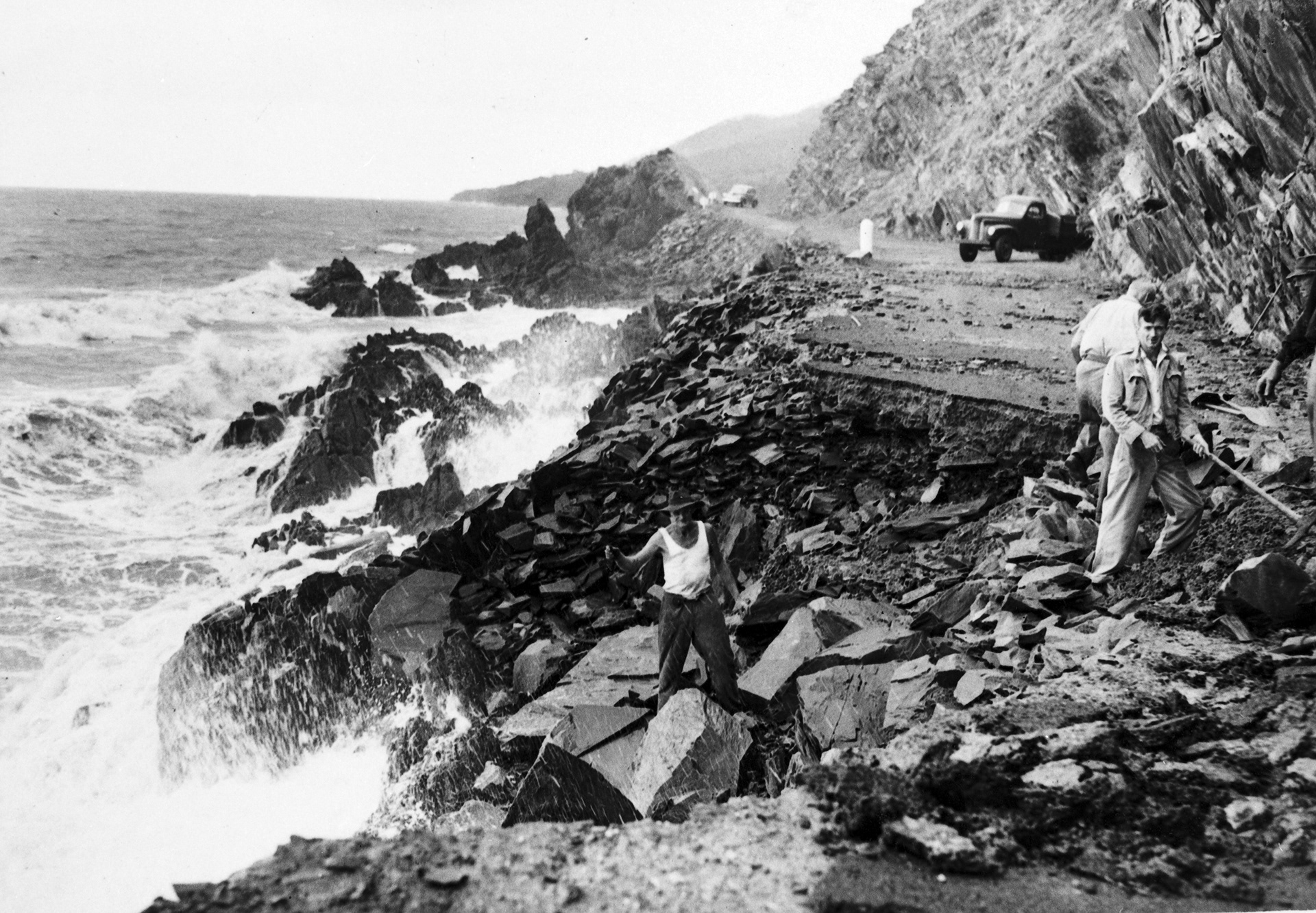 Road damage after cyclone, Shot of Redcliffe Point showing washouts as a result of cylonic disturbence. Men working