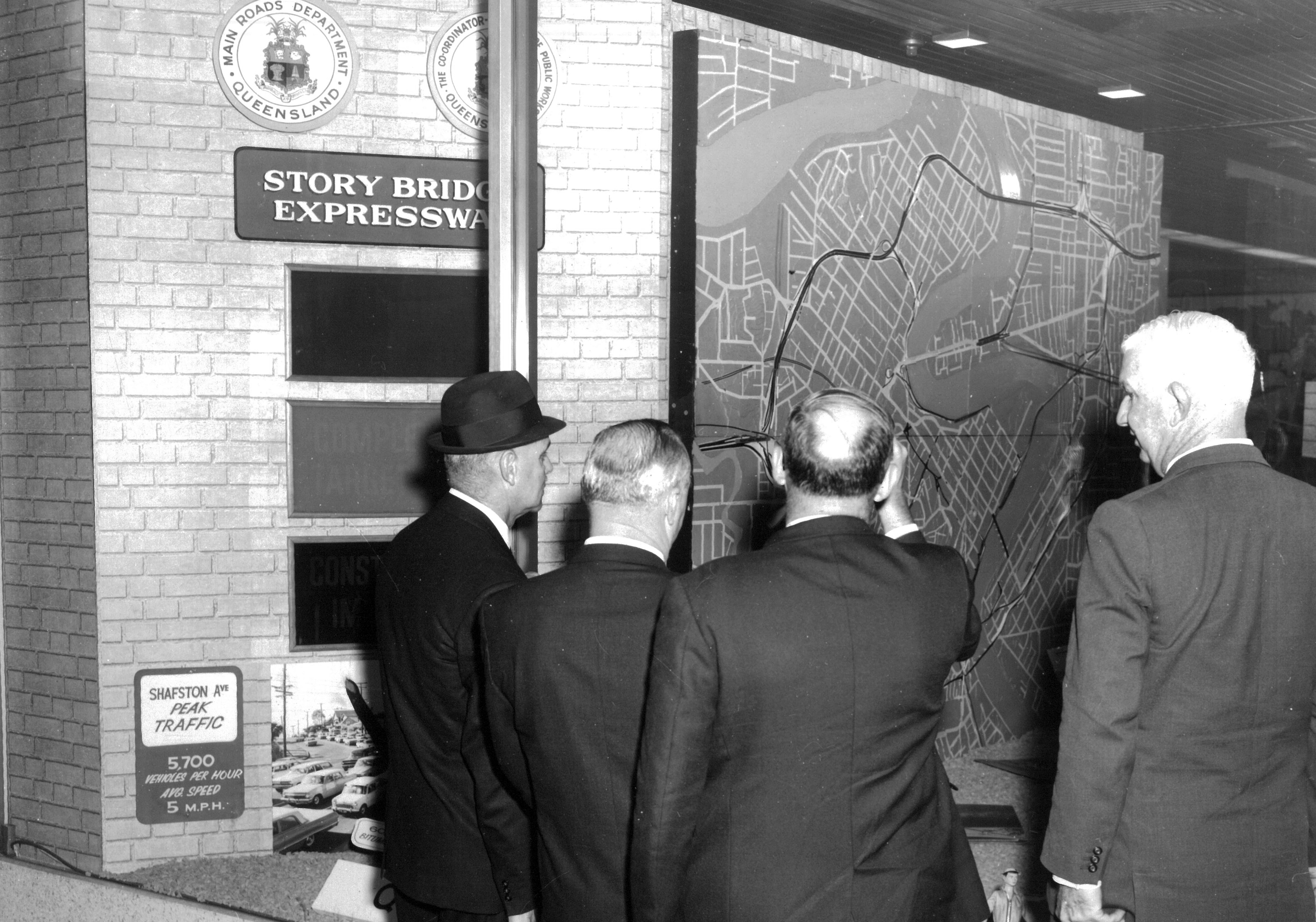 Four members of the public looking through a window at the Story Bridge Expressway display