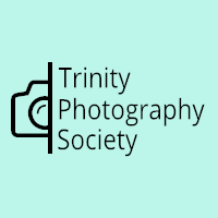 Half of a Camera Icon,  a line down the side on with "Trinity Photography Society"