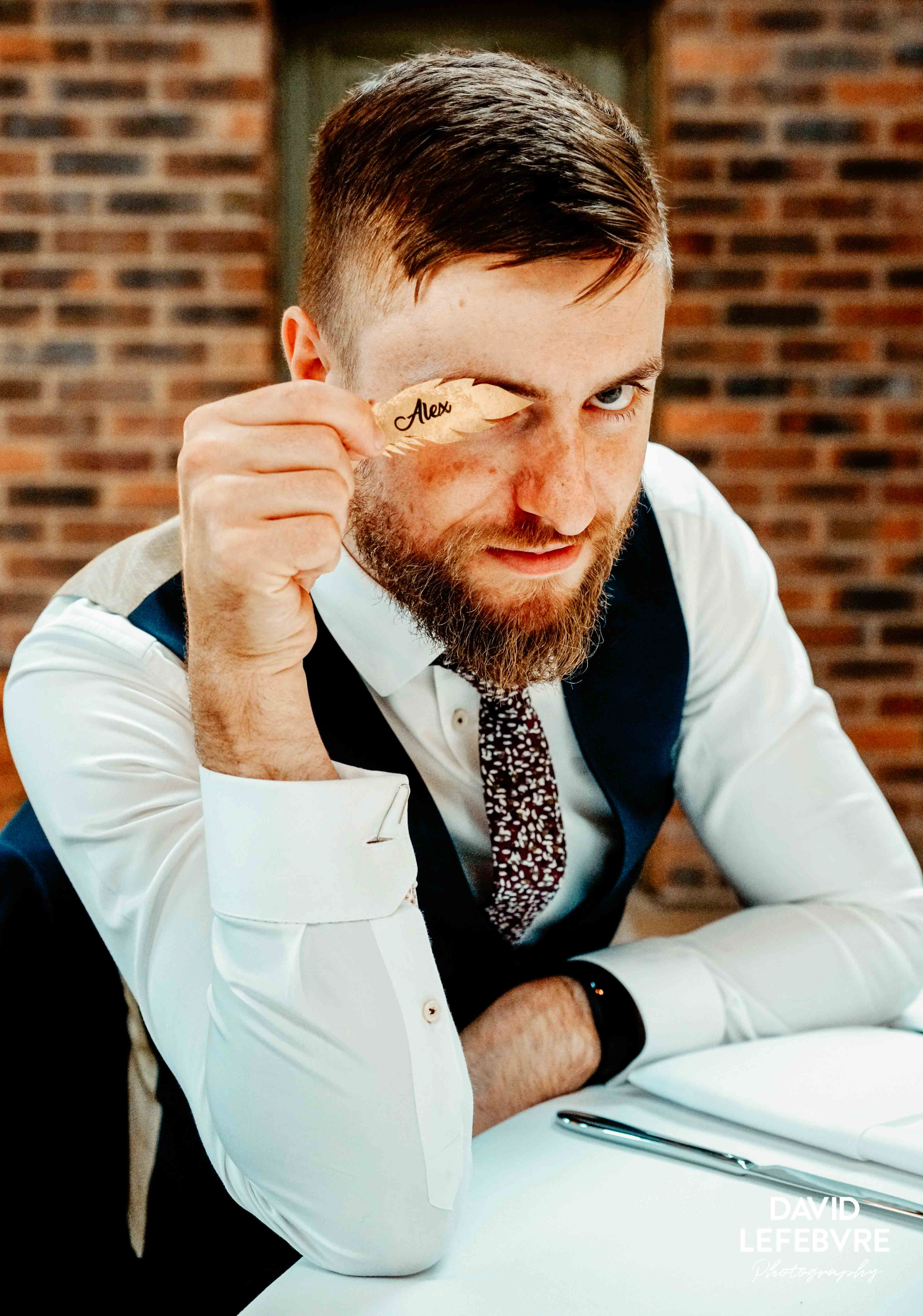 alex gold leaf held over right eye at owen barn house wedding venue