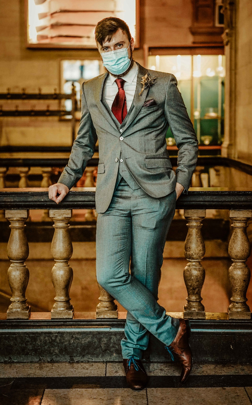 wedding photo of groom stood in ted baker suit in ppe mask at covid wedding in oxford town hall with photographer david lefebvre
