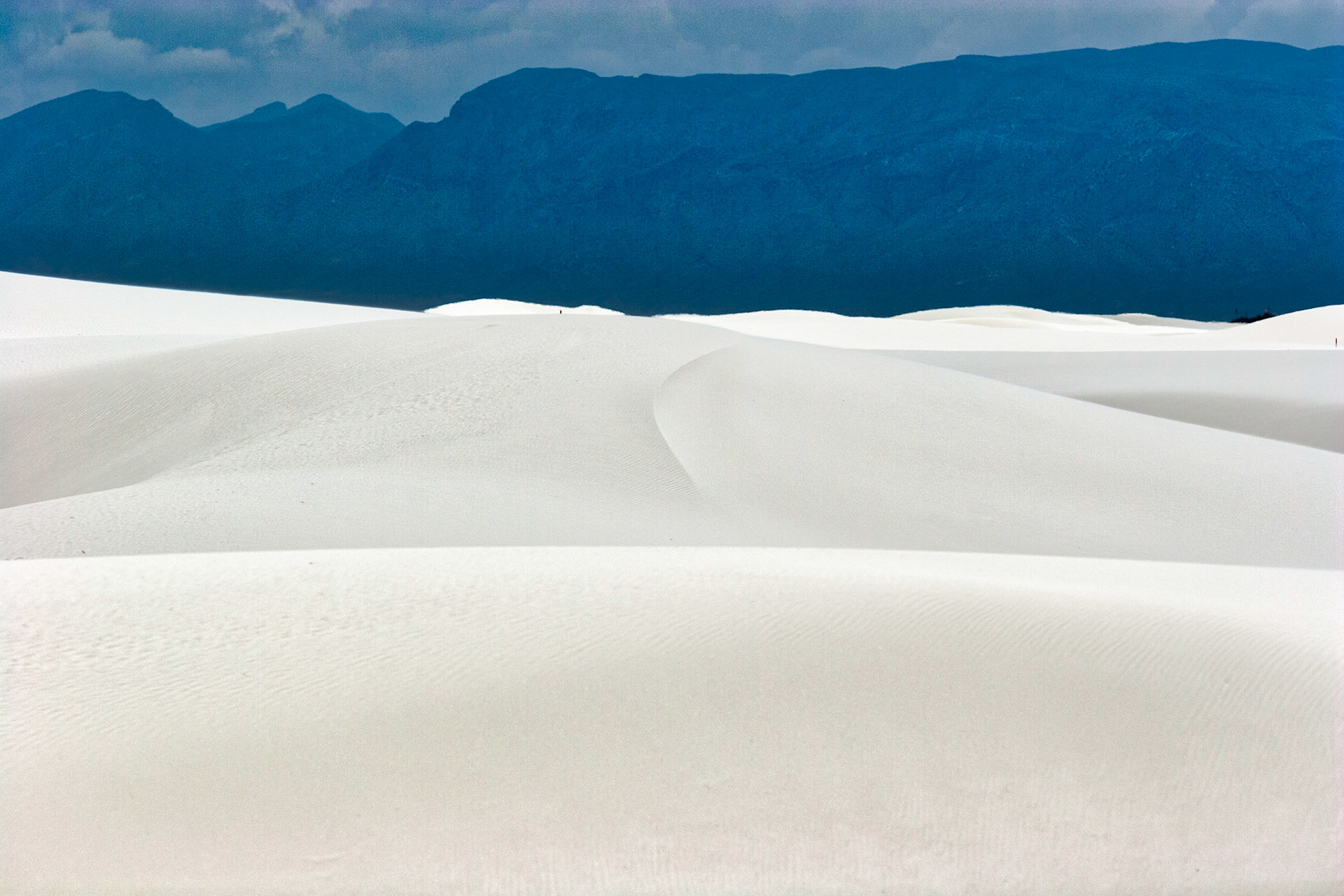 White Sands National Monument, New Mexico. Rising from the heart of the Tularosa Basin is one of the world's great natural wonders - the glistening white sands of New Mexico. Great wave-like dunes of gypsum sand have engulfed 275 square miles of desert, creating the world's largest gypsum dunefield. White Sands National Monument preserves a major portion of this unique dunefield, along with the plants and animals that live here.