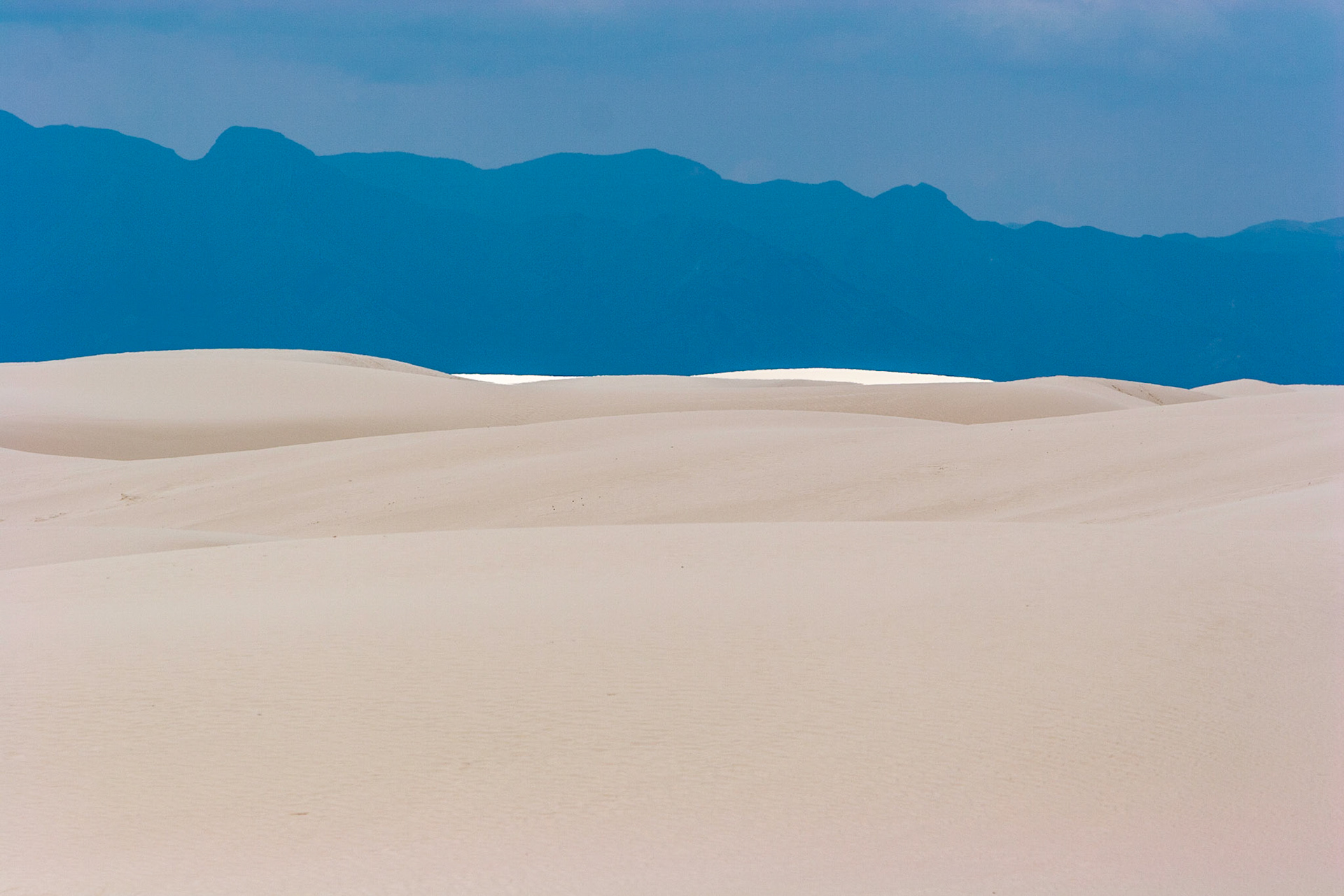 White Sands National Monument, New Mexico. Rising from the heart of the Tularosa Basin is one of the world's great natural wonders - the glistening white sands of New Mexico. Great wave-like dunes of gypsum sand have engulfed 275 square miles of desert, creating the world's largest gypsum dunefield. White Sands National Monument preserves a major portion of this unique dunefield, along with the plants and animals that live here.