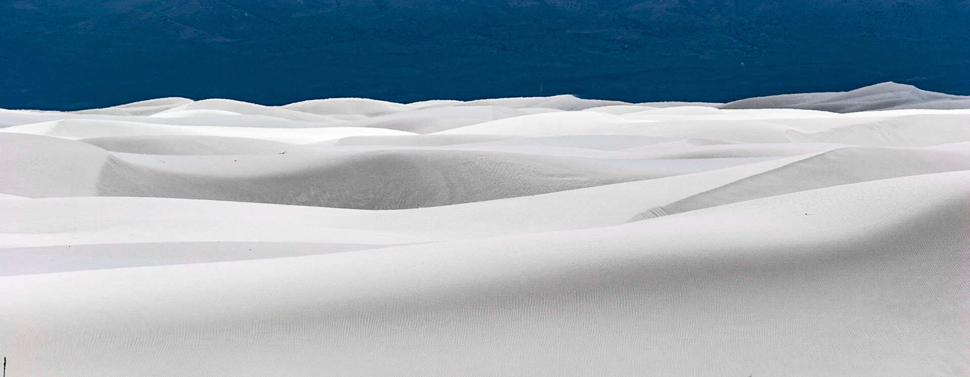 White Sands National Monument, New Mexico. Rising from the heart of the Tularosa Basin is one of the world's great natural wonders - the glistening white sands of New Mexico. Great wave-like dunes of gypsum sand have engulfed 275 square miles of desert, creating the world's largest gypsum dunefield. White Sands National Monument preserves a major portion of this unique dunefield, along with the plants and animals that live here.