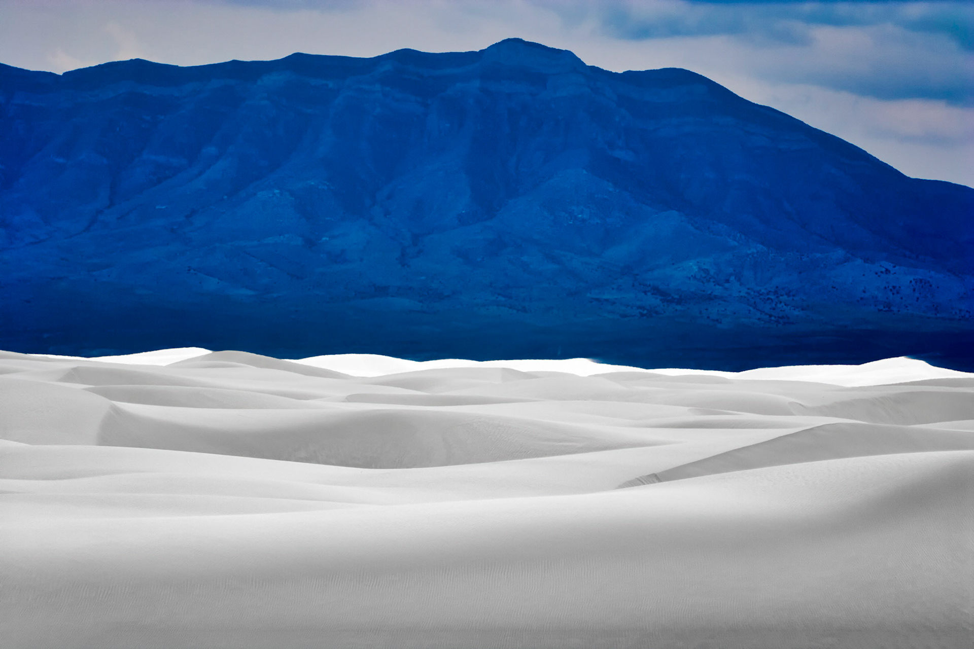 White Sands National Monument, New Mexico. Rising from the heart of the Tularosa Basin is one of the world's great natural wonders - the glistening white sands of New Mexico. Great wave-like dunes of gypsum sand have engulfed 275 square miles of desert, creating the world's largest gypsum dunefield. White Sands National Monument preserves a major portion of this unique dunefield, along with the plants and animals that live here.