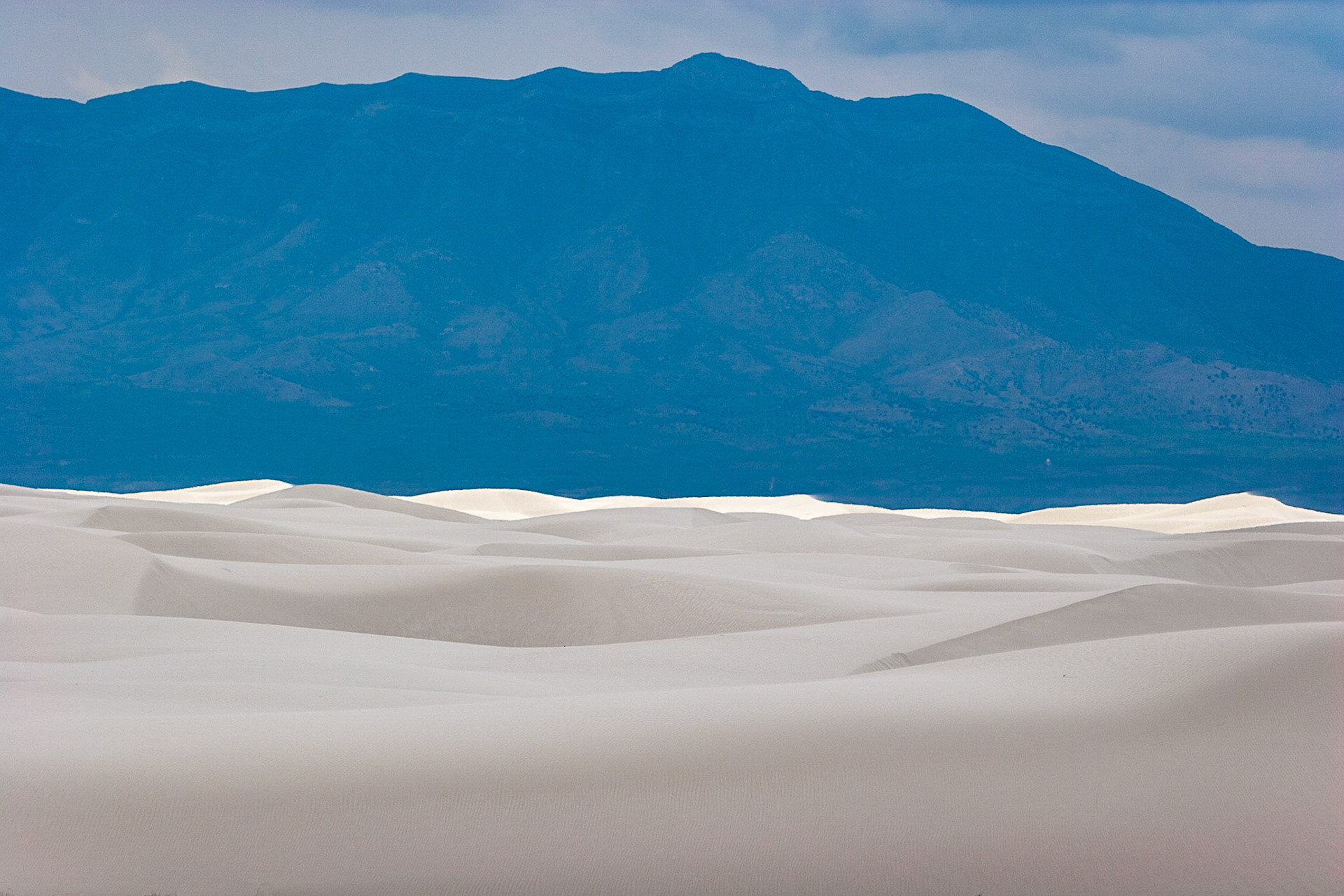 White Sands National Monument, New Mexico. Rising from the heart of the Tularosa Basin is one of the world's great natural wonders - the glistening white sands of New Mexico. Great wave-like dunes of gypsum sand have engulfed 275 square miles of desert, creating the world's largest gypsum dunefield. White Sands National Monument preserves a major portion of this unique dunefield, along with the plants and animals that live here.