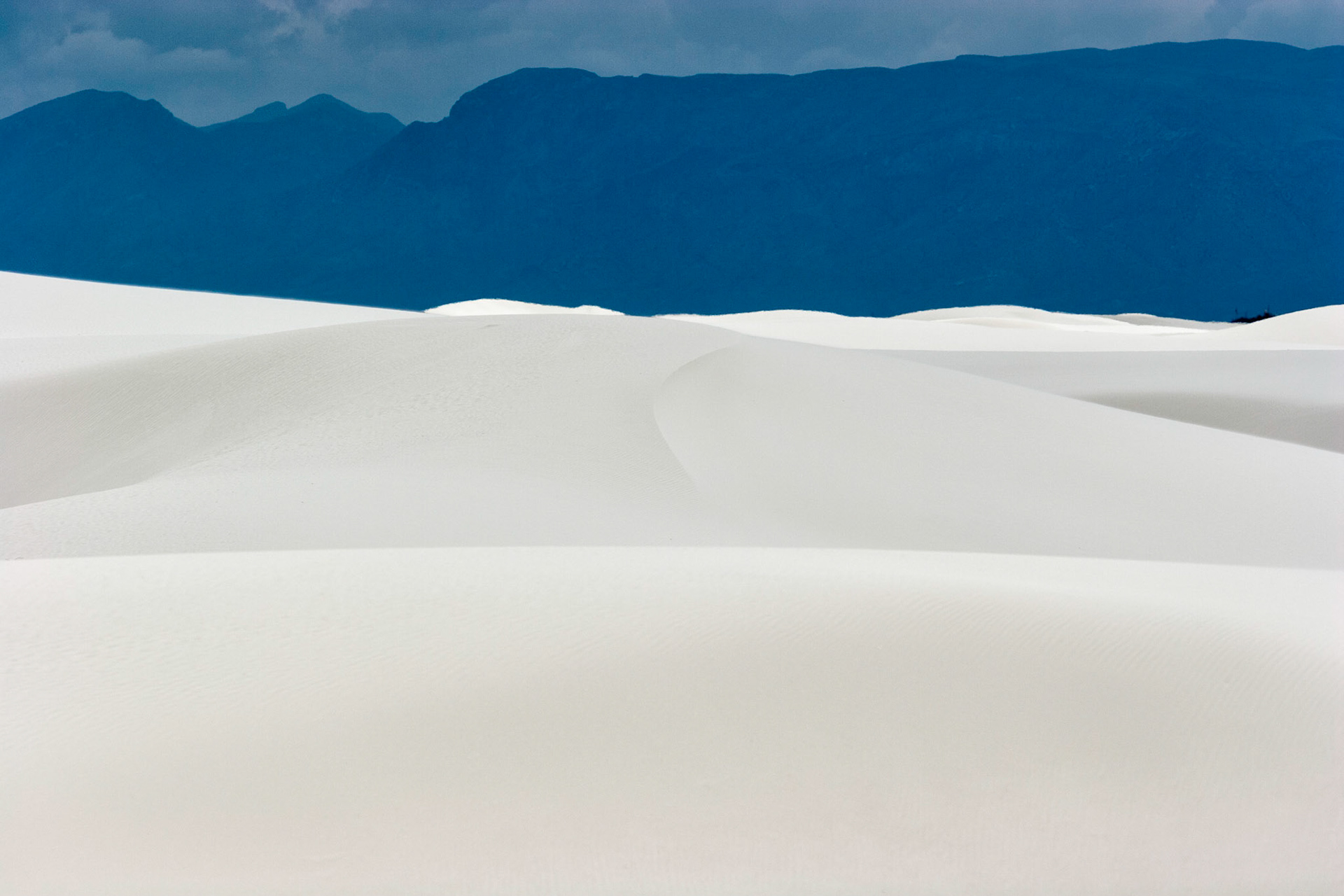 White Sands National Monument, New Mexico. Rising from the heart of the Tularosa Basin is one of the world's great natural wonders - the glistening white sands of New Mexico. Great wave-like dunes of gypsum sand have engulfed 275 square miles of desert, creating the world's largest gypsum dunefield. White Sands National Monument preserves a major portion of this unique dunefield, along with the plants and animals that live here.