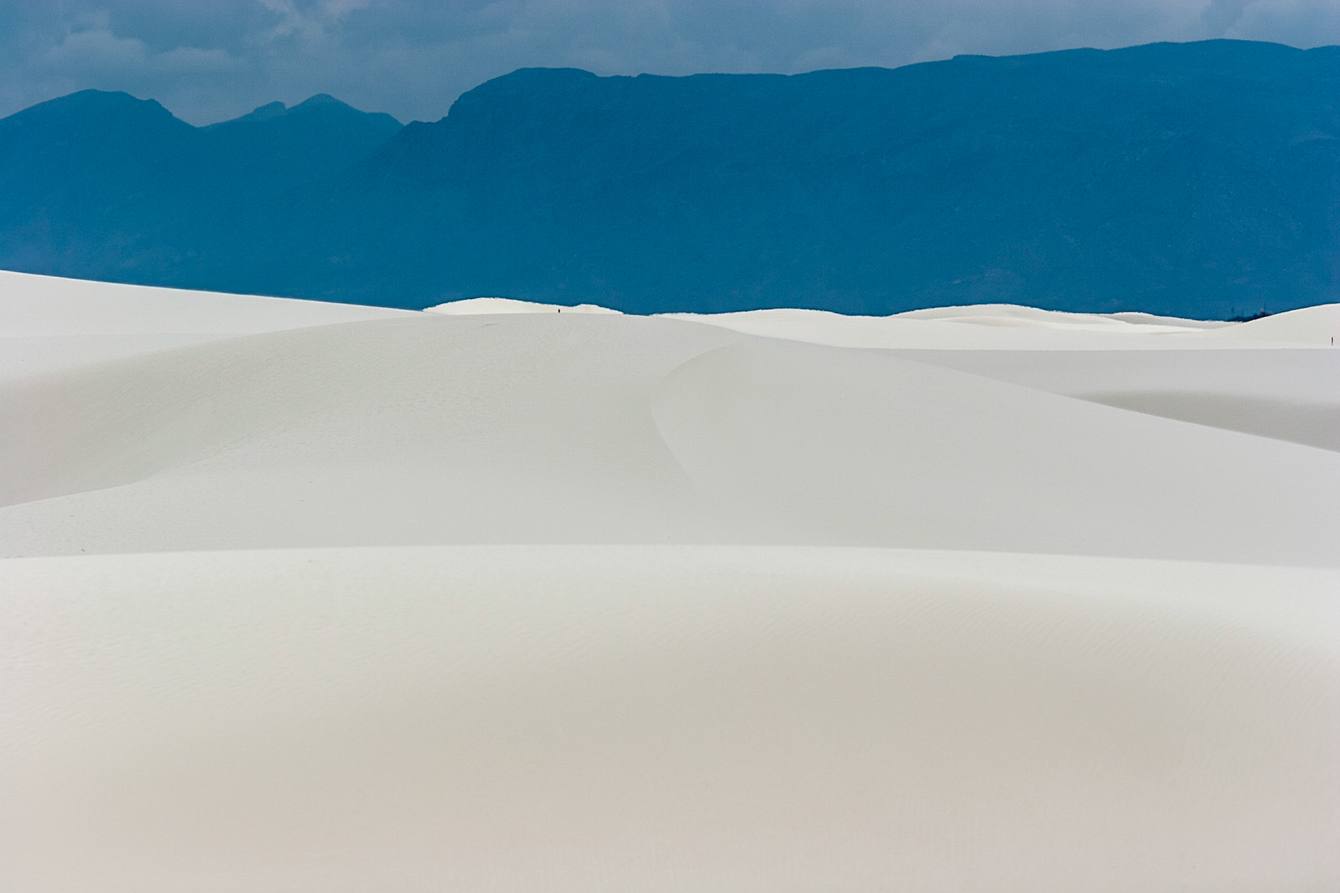 White Sands National Monument, New Mexico. Rising from the heart of the Tularosa Basin is one of the world's great natural wonders - the glistening white sands of New Mexico. Great wave-like dunes of gypsum sand have engulfed 275 square miles of desert, creating the world's largest gypsum dunefield. White Sands National Monument preserves a major portion of this unique dunefield, along with the plants and animals that live here.