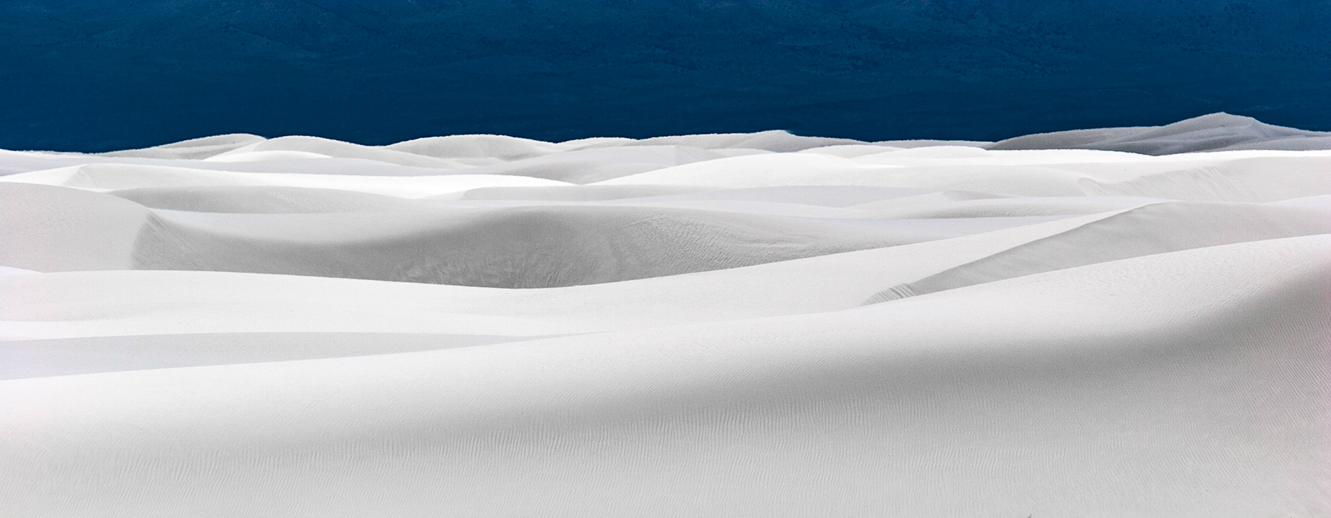 White Sands National Monument, New Mexico. Rising from the heart of the Tularosa Basin is one of the world's great natural wonders - the glistening white sands of New Mexico. Great wave-like dunes of gypsum sand have engulfed 275 square miles of desert, creating the world's largest gypsum dunefield. White Sands National Monument preserves a major portion of this unique dunefield, along with the plants and animals that live here.