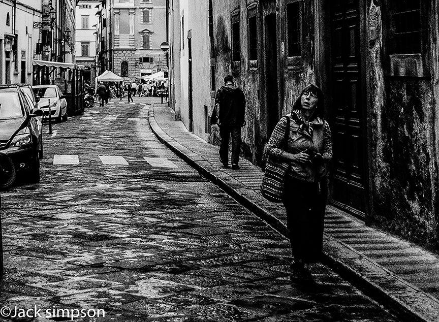 Image focuses on a photographer wandering the back streets of Florence, Italy in search of that elusive photograph that all photographers know so well. The image was shot on a damp wet day, to which I have added additional "noise" or grain to emphasise the damp weather