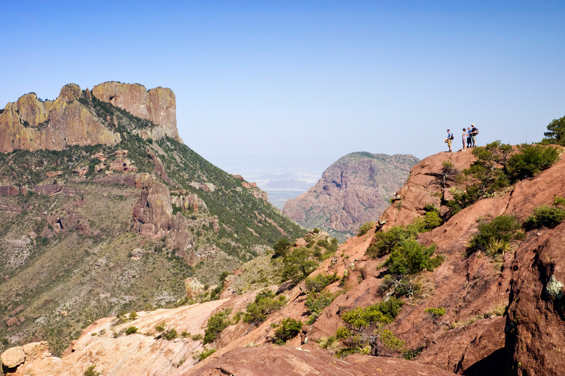 Hikers reach the summit and take in the view of Casa Grande from Lost Mine Trail in Big Bend National Park in Texas.
