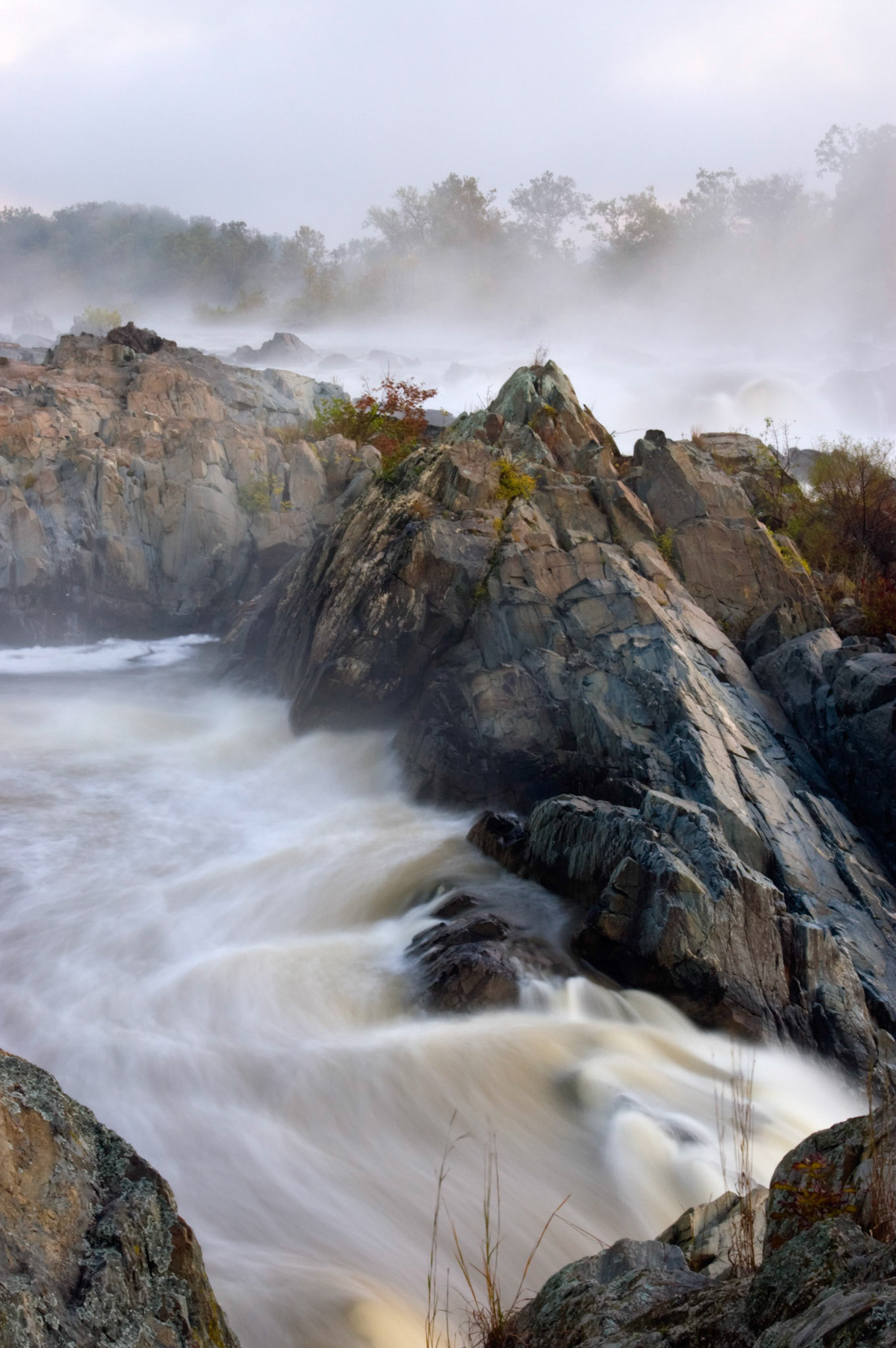 A dawn view of a misty, rocky waterfall at Great Falls National Park in Virginia.