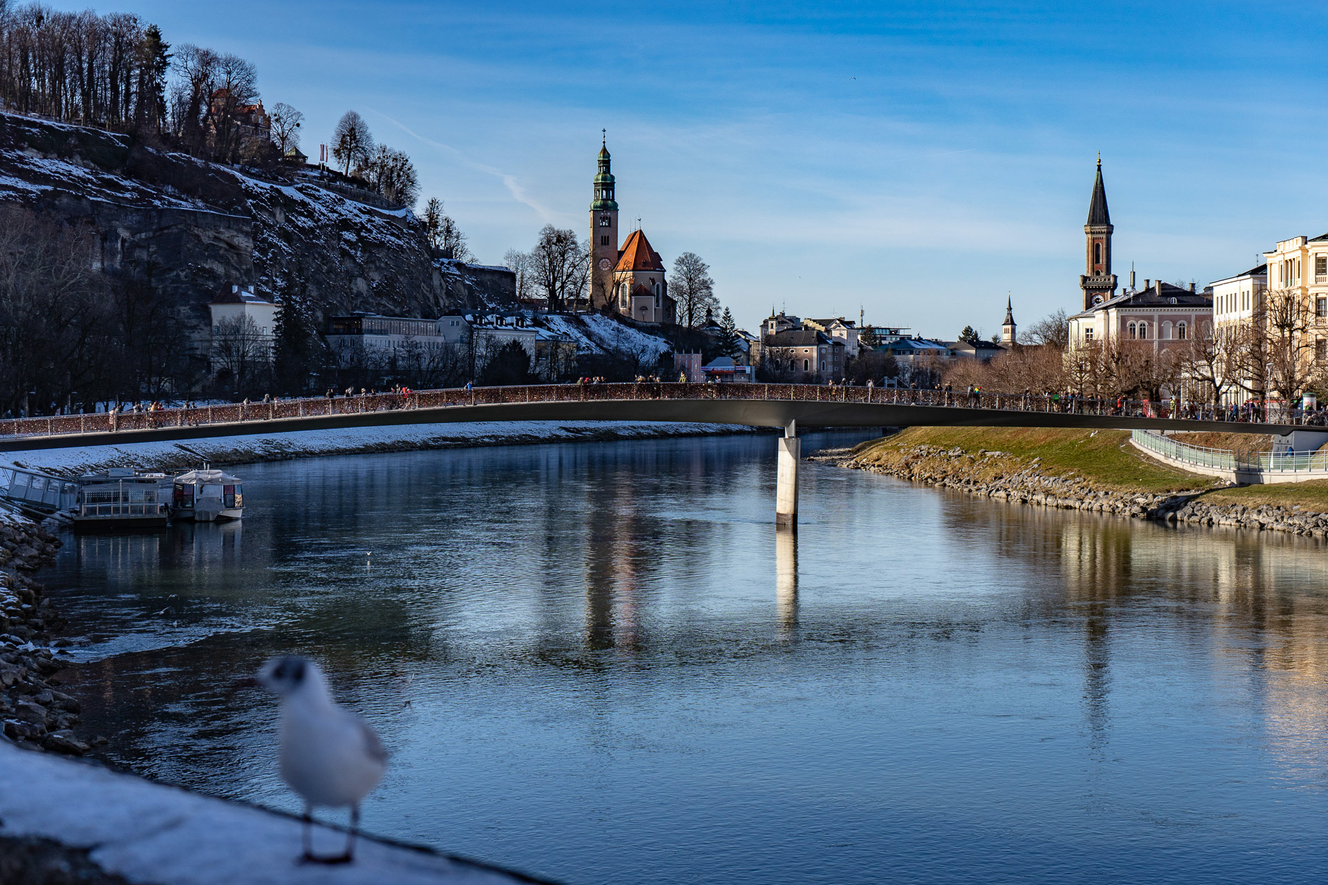 The river Salzach with the pedestrian bridge Makartsteg, right behind the Protestant church Christuskirche and in the background on the left the catholic chruch Maria Himmelfahrt, heiliger Augustinus, heiliger Alexius von Rom