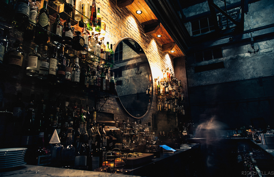 Rigel Hellas photograh of a wall of liquor and two spirits in the Ice plant Bar and Restaurant in St. Augustine Florida